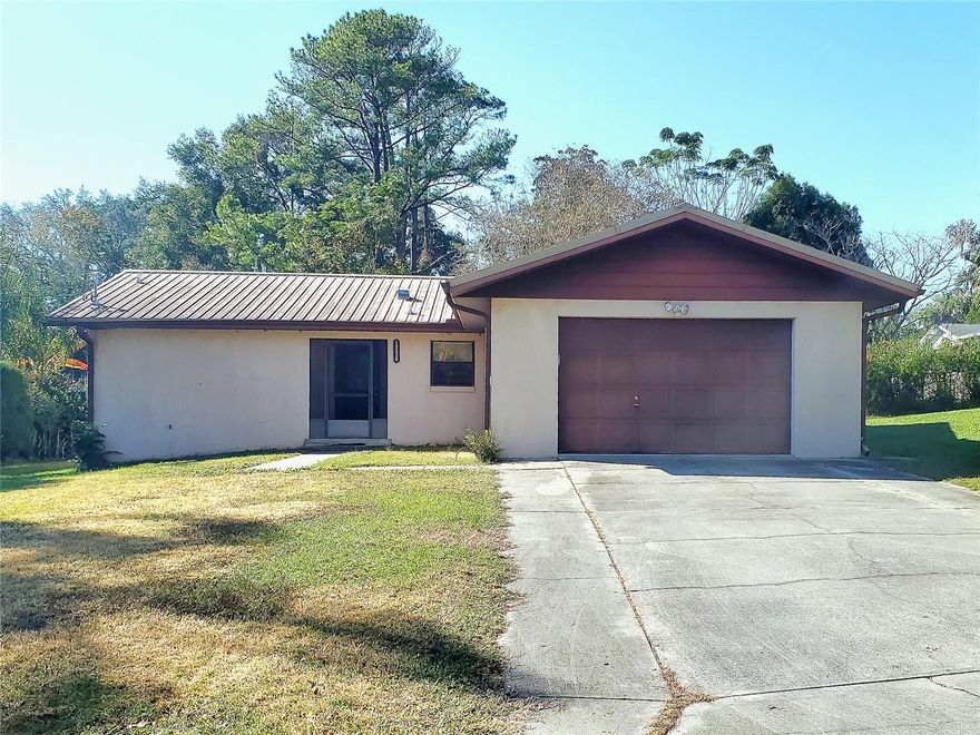 Great Bones! This 1984 block-and-stucco 2/2 sits on an oversized lot with both a well and septic system.  No HOA or CDD so the money stays in your pocket. Features: Metal Roof, HVAC 2022, H20 heater 2023. A bit of TLC will go a long way toward personalizing the spaces of the home. The welcoming foyer features a screened, tiled entry—perfect for those rainy Florida days. Step into the spacious living room, large enough for a sectional and big-screen TV. A galley styled kitchen offers a SS stove, updated sink and cabinetry and a breakfast bar for a quick bite to eat. The primary bedroom features a huge walk-in closet a primary bath updated with a linen closet and newly installed vanity. Beyond that, a huge family room featuring a cozy fireplace and back door access to the newly installed back wooden deck leading into to a fully fenced, expansive backyard big enough for a pool or your fur babies or both! The garage houses the laundry and a generator already connected and ready to go.  This home is a must-see at this price! Call today for a private tour.