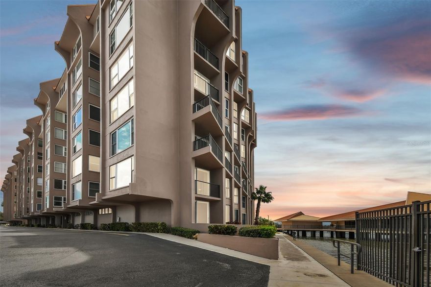 Welcome to your coastal sanctuary in the sought-after 55-plus community of Edgewater Arms, where breathtaking waterfront views meet modern luxury. This beautifully renovated condominium, completely updated in 2015, showcases a blend of style, comfort and durability, with impact windows throughout for peace of mind. Go inside to unobstructed vistas stretching to Caladesi Island and beyond. The expansive living room, featuring an electric fireplace and custom-built entertainment bar with wine cooler, is ideal for relaxing or entertaining. Glass sliders lead to your private balcony, where sea breezes and stunning sunsets become part of your everyday life. The kitchen flows seamlessly into the dining area and offers a large walk-in pantry for all your culinary needs. The primary suite is a retreat, with a spa-like bath, dual vanities and a spacious walk-in closet. Two additional bedrooms and a full guest bath provide comfort for family or friends, while the in-unit washer and dryer make everyday living easy. Edgewater Arms offers an array of amenities designed for leisure and connection, such as heated waterfront pool, kayak launch, shuffleboard courts, ping pong and billiards, and a tiki hut with a gas grill for social gatherings by the water. Enjoy sunsets from the serene waterfront park or visit downtown Dunedin, with its restaurants, cafes, breweries, live music, art festivals and more. Just minutes from Dunedin Marina, Honeymoon Island beaches and the Toronto Blue Jays spring training ballpark, this location combines an active lifestyle with peaceful coastal living.