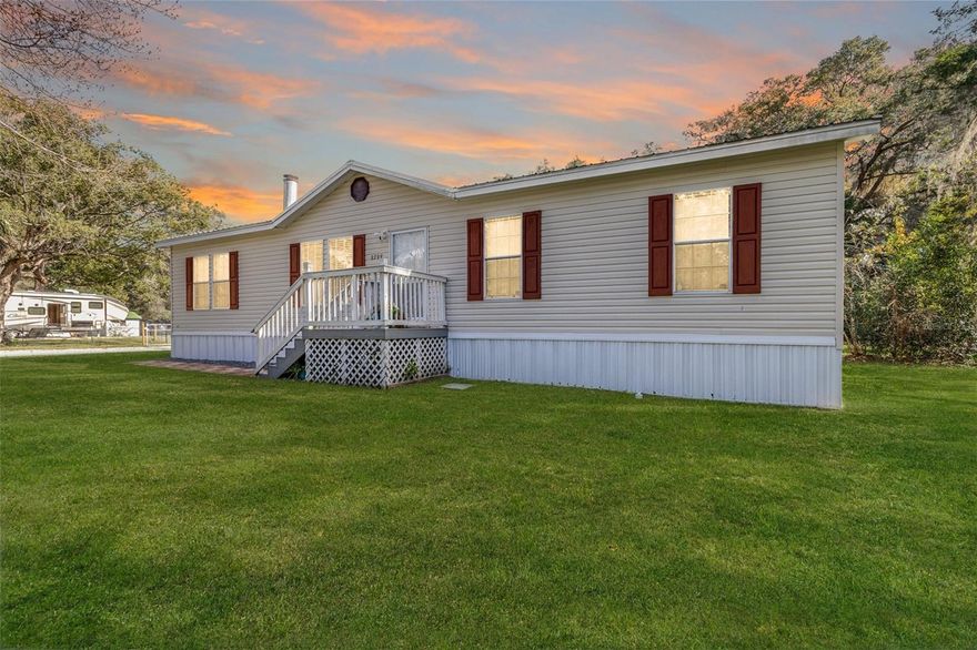 Spacious 4-bedroom, 2-bath manufactured home situated on nearly an acre in desirable Southeast Ocala with NO HOA. This property offers far more than the typical mobile home, featuring a fully enclosed carport converted into a large bonus space—ideal for a man cave, home office, or mother-in-law suite—while still allowing room for one vehicle. Built in 2007 and located in Ocala, the Horse Capital of the World, this home is conveniently near the World Equestrian Center and sits on a fully fenced 0.99-acre lot. Inside, the split floor plan provides privacy, with a spacious primary suite offering a walk-in closet, garden tub, and separate shower. The living room features a cozy fireplace, and the island kitchen and main living areas are enhanced by fresh interior paint, laminate flooring, crown molding, and window blinds throughout. Major upgrades include a metal roof, new well, new HVAC system with heat pump and emergency electric coil, new insulation, and a newly installed A/C unit. The converted 14x18 carport space includes electric, water, and A/C, providing excellent flexibility for additional living or guest space. Additional improvements include an 18x18 concrete block building, a 12x24 workshop with 60-amp service, and an outbuilding with electric and water. The property also features a new power pole with 50-amp connection, along with water and septic already in place. Mature cedar trees add privacy and curb appeal, while the expansive lot offers plenty of room for RVs, boats, trailers, or future expansion. With extensive upgrades, multiple usable structures, and versatile living spaces, this property delivers comfort, flexibility, and true Florida living.