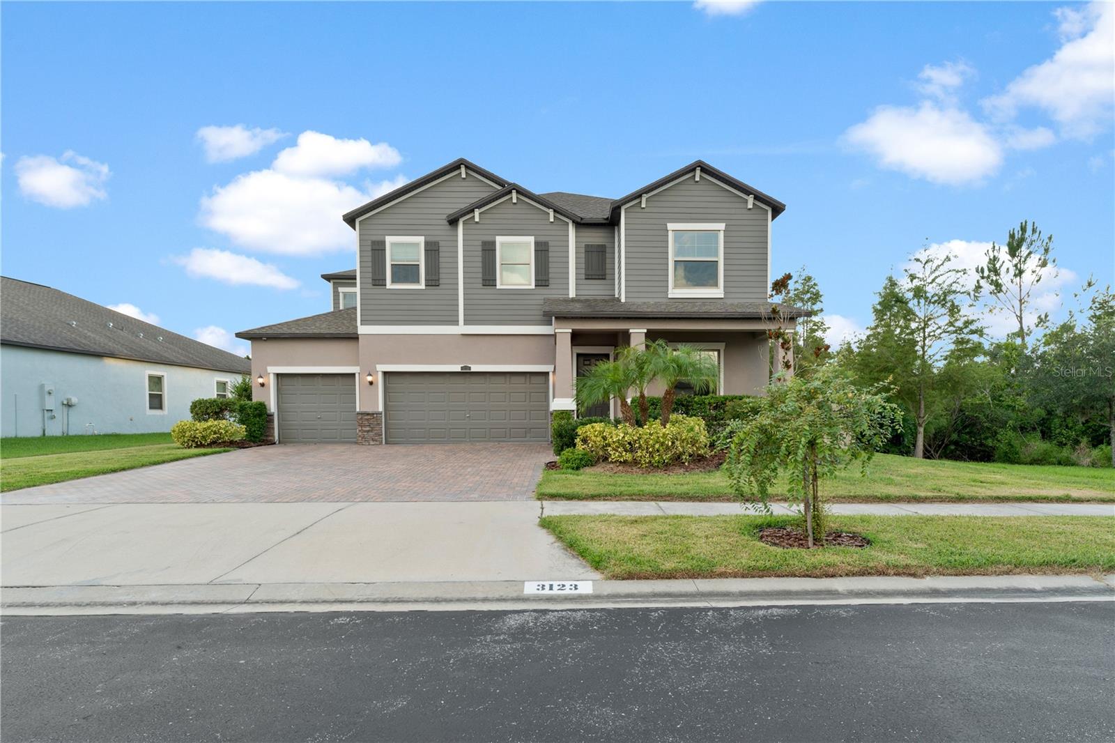 Welcome to this beautifully designed 5 bedroom, 3 bathroom, 3 car garage, two-story home with a pool; offering style, space, and modern upgrades throughout. From the moment you arrive, the impressive curb appeal shines with a wide paver driveway, fresh landscaping, and a welcoming covered entry. Inside, the foyer opens to bright and airy living spaces highlighted by neutral tones and elegant tile flooring laid in a diamond pattern.The heart of the home features a spacious living room with a custom floor-to-ceiling stacked stone accent wall, complete with a sleek electric fireplace and a built-in niche for your entertainment setup. Large windows fill the room with natural light.The open floor plan flows beautifully into the dining area with modern lighting and easy access to the outdoor living space through sliding glass doors. Where you can enjoy views of the private backyard and pool, creating a seamless indoor-outdoor lifestyle. The expansive kitchen, a true centerpiece of the home, features crisp white cabinetry, sleek granite countertops, and a spacious center island, this kitchen combines both style and function. Stainless steel appliances, a built-in microwave, and abundant counter space make it ideal for both everyday meals and entertaining. A convenient desk nook adds flexibility for work, homework, or recipe planning.Upstairs, you will find 3 additional bedrooms and a full bathroom, providing plenty of room for family and guests. A versatile loft space adds flexibility, perfect for a playroom, home office, or media area.The highlight of the second floor is the expansive primary retreat, a private haven designed for comfort. The bedroom offers ample space, with soft natural light streaming through the windows. Natural tones and plush carpeting creates a relaxing atmosphere. The ensuite math is equally impressive featuring dual vanities with granite countertops, a large soaking tub as the centerpiece, and a separate glass-enclosed shower. The bathroom flows seamlessly into an expansive custom walk-in closet with built-in shelving, drawers, and abundant hanging space - a true dream for organization and storage. Last but not least, is the private backyard oasis. A large covered lanai with ceiling fan and mounted TV creates the perfect space to relax or entertain, with the outdoor kitchen - complete with built-in grill and refrigerator - makes dining pool side effortless. The sparkling pool with integrated spa invites you to unwind, framed by a large paver patio. The backyard continues with a fire pit seating area, ideal for cozy evenings under the stars. With no rear neighbors and a backdrop of lush greenery, this outdoor retreat provides both privacy and tranquility. Whether it’s summer pool parties, weekend barbecues, or quiet nights by the fire, this space delivers the ultimate Florida lifestyle.
