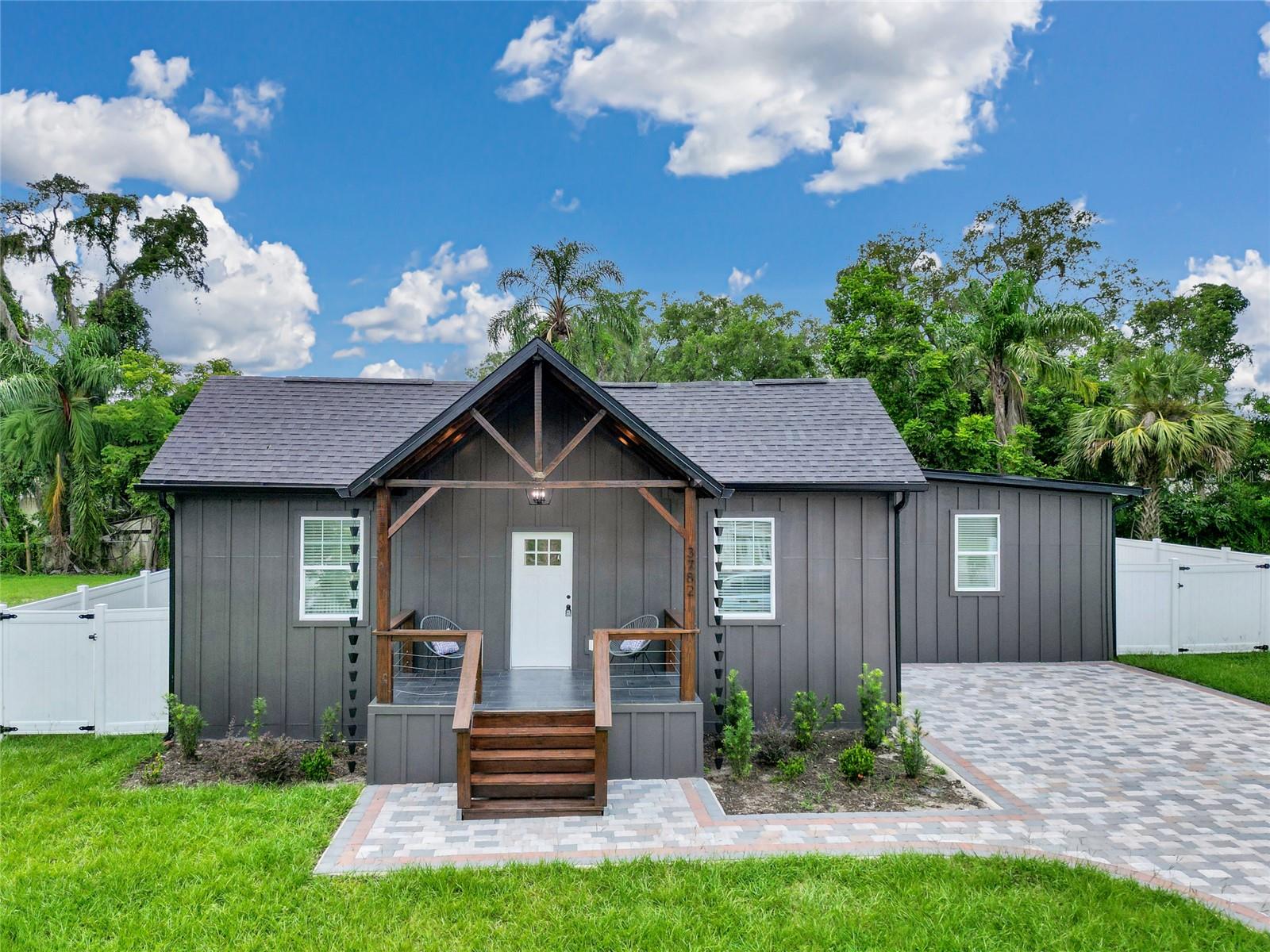 Modern-ranch perfection. Behind the striking curb appeal—expansive paver driveway and a wood-stained tongue-and-groove front porch—over 1,800 SF unfolds in a bright split plan with all the feel-good upgrades and a fenced yard made for real life. The chef’s kitchen is the heart of the home with a large island and eat-in counter, waterfall quartz, new soft-close shaker solid wood cabinetry, and brand-new stainless appliances, while a chic half bath nearby shows off designer floor tile and an elegant vanity. Two serene bedrooms off the naturally lit living room share a marble-tiled bath with a luxe vanity and tub (one bedroom boasts an oversized walk-in closet). On the quiet wing, a third bedroom sits near the expansive primary suite with walk-in closet and a luxurious-styled bath finished in modern tile with a walk-in shower. Daily function shines with a dedicated dining room and a true laundry room with utility sink and storage. Thoughtful details are everywhere in this practically brand new home: 2-panel doors, new trims and moldings, fresh drywall finish/texture, brand-new A/C, upgraded plumbing, double-pane windows, and spray insulation for comfort and efficiency. Outdoors, nearly a quarter-acre of fully fenced yard invites morning coffee, weekend cookouts, pets at play, and room to garden—plus no HOA. Minutes to Publix and everyday shopping with quick 429 access across town, this four-bed, 2.5-bath modern renovation delivers crisp design, low-maintenance living, and the kind of indoor-outdoor flow that wins hearts.