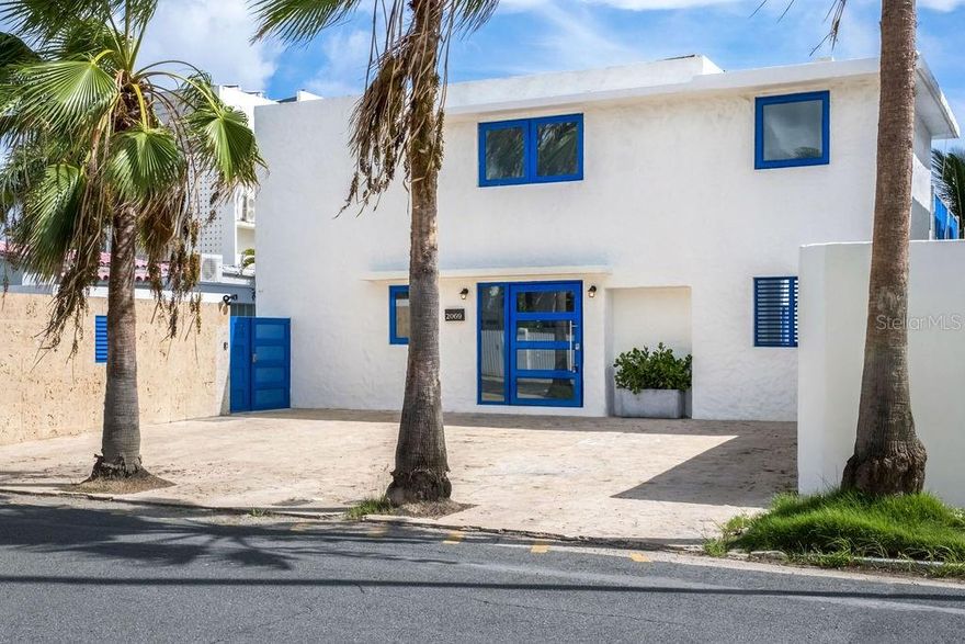 Transport yourself to the shores of the Aegean with this Grecian-inspired gem, located in San Juan’s most exclusive and sought-after gated oceanfront community, Ocean Park. Mere steps from the city’s most desirable beaches, this exceptional property radiates Mediterranean charm, seamlessly blending its iconic white-and-blue Santorini aesthetic with the vibrant energy of the Caribbean to create a truly one-of-a-kind experience.

 Nestled in a 470 SM lot, this home spans 5,300 square feet and consists of two Cycladic-style buildings, beautifully connected by an enchanting central patio. The layout is designed to integrate both buildings harmoniously, creating an effortless flow that caters to both large gatherings and intimate retreats. With 9 elegantly designed bedrooms, 9 full bathrooms, and 3 half baths, this residence can comfortably accommodate up to 23 guests.

The main building includes five bedrooms, three of which are located on the second floor, accessible via an interior staircase, and two with private exterior entrances. The second building offers four additional bedrooms, one with a grand balcony with sweeping ocean views. Each bedroom is equipped with its own private en-suite bathroom, ensuring ease and privacy throughout the home. An additional storage room provides versatility, easily convertible to a guest room or home office.

From the moment you arrive, the whitewashed stucco facade and royal-blue trims immediately captivate, setting the Mediterranean theme throughout the property. The grand entrance is complemented by a spacious 4-car parking area, leading into the home’s thoughtfully designed spaces. The layout is centered around a bright, fully furnished open concept space, perfect for hosting large gatherings or relaxing with family. The kitchen, located just beyond the living area, is equipped with ample white-and-blue countertops, modern appliances, and a charming corner coffee bar. The kitchen’s Santorini blue-framed back doors open directly onto the central patio, allowing for a seamless connection between the indoor and outdoor spaces.  

The patio stands at the heart of the property, and features a pool surrounded by soft overhead lighting that sets the perfect tone for evening gatherings. Multiple shaded lounging areas provide serene spots to relax and enjoy the ocean breeze, while the exterior dining and barbecue areas are perfect for hosting memorable al fresco meals. A beautifully crafted accent wall completes the Mediterranean ambiance, adding to the overall charm of the space. Additional features include a covered playroom, outdoor shower, two exterior half baths, and a laundry area. The property is fully furnished and equipped with all the essentials, including a generator and water cistern.

This property presents an incredible turnkey investment opportunity. As a high-performing short-term rental, it offers a remarkable and proven track record of positive returns and attractive cash flow.

Located in the heart of Ocean Park, this property offers easy access to Condado Beach, trendy Loíza Street, top-ranking schools and Luis Muñoz Marín International Airport. Enjoy sophisticated restaurants, boutique shopping, parks, and outdoor activities like surfing, swimming, beach tennis, and kiteboarding within walking distance.
