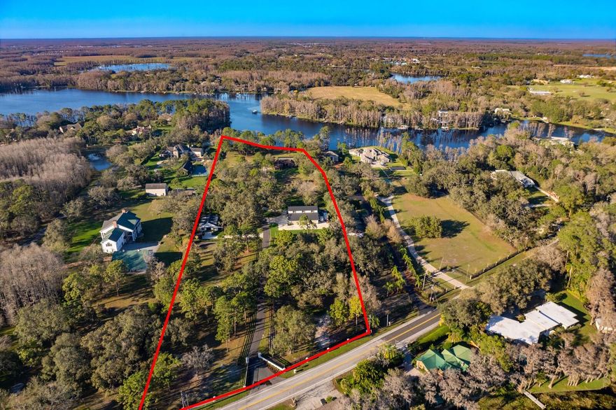 GATED EQUESTRIAN 12+ ACRE LAKEFRONT PARCEL WITH NEW BARN AND NEW 5,468 AC 9 CAR + RV STORAGE GARAGE. This is now a combined parcel (previously 10103 and 10101 Tarpon Springs Rd) with over $2.5M in improvements since purchase. Welcome to endless recreation on and off the water, abundant wildlife and the perfect blissful lake lifestyle. Located on approximately 12.44 acres (8.45 upland) and over 300 ft of lake frontage, embrace all that this Keystone community provides, promising unparalleled Lake Island Ford water views, direct lake access and endless possibilities for luxury living. Offering assembled acreage fenced and gated with brand new equestrian amenities – READY FOR CONSTRUCTION OF A NEW SINGLE-FAMILY HOME. (See Rendering. New Home Plans are available. Cost of home construction not included in price) Pristine fenced pasture and a newly constructed 3 Stall state-of-the-art barn await your imagination for this spectacular location. Every detail has been addressed in the modern barn, from the foundation up including Anderson Impact windows. Lucas equine rolling doors, timer controlled lighting and a fly spray system indoors and out are only the beginning. Customized for the discerning equestrian, appointments include air-conditioned tack, feed and hay room, separate wash rack, custom walls and floors, ceiling fans, automatic watering system, separate covered shed, along with a brick floor aisleway and front porch. Beyond plentiful fenced pasture, there is a 60-foot round pen and additional open pasture. The 5,468 sqft air-conditioned freestanding garage features concrete block/ Anderson impact window construction and houses approximately 9-vehicles plus RV storage, along with future living/guest space above. Additionally, a new private dock and covered boat lift provide for the best of water recreation, boating, skiing and coveted lake life. Though a peaceful setting that feels like the great escape, this marvelous location is near parks and trails, shopping, dining, with highly regarded schools and activities for all ages. Property being sold for land value. Existing residential structure has no contributory value and new construction home has been planned.