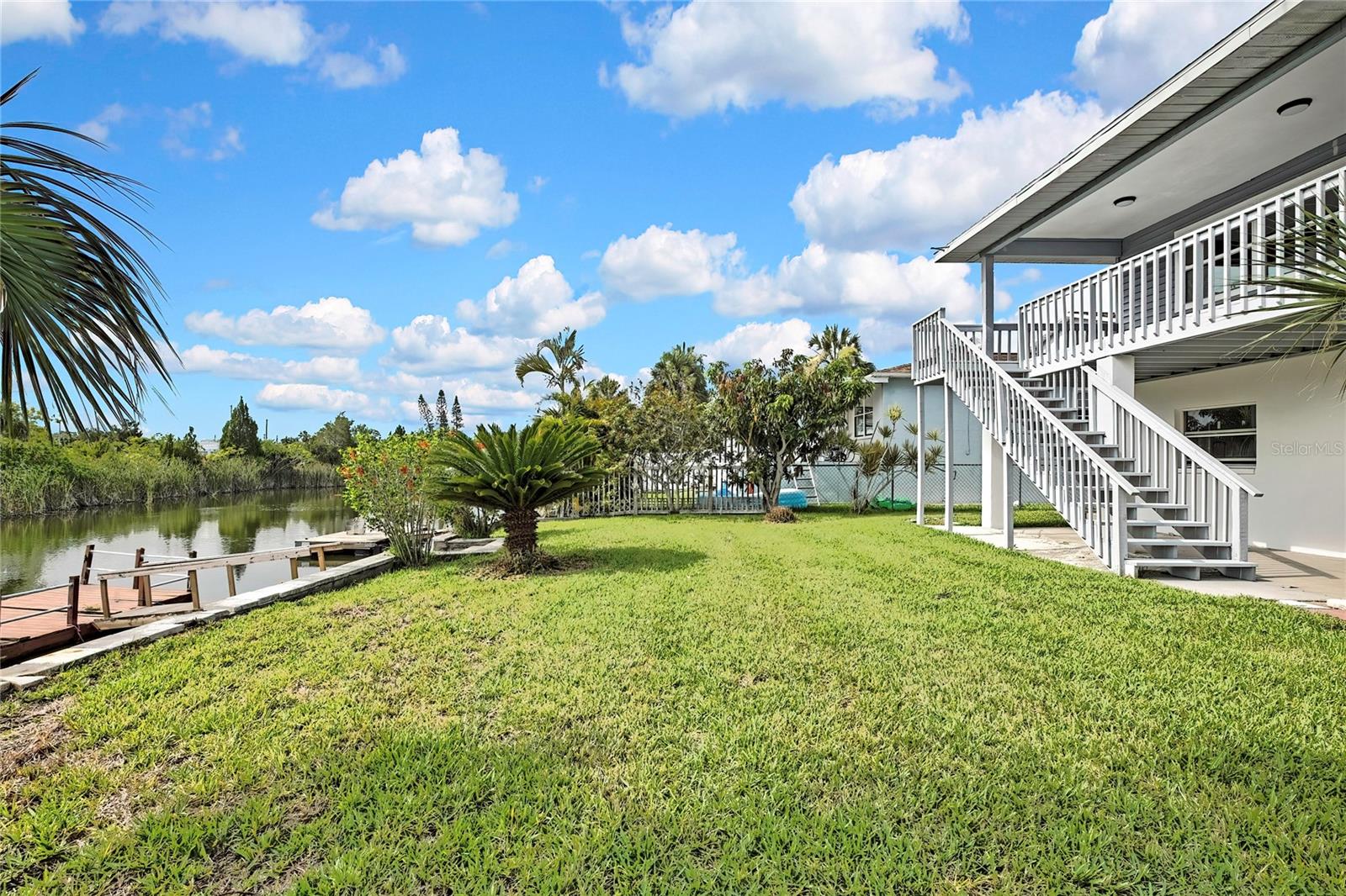 Beautiful Waterfront stilt home with seawall/knee-wall and dock. Main level offers open floor plan with plenty of natural light and views of the water. Large, Renovated Kitchen with plenty of cabinets, granite counters, Huge Center Island, space and room for barstools. Dining area flows to the Balcony offering outside dining as well as lower-level covered lanai. Back of home faces East so you can relax in the evening hours without glaring sun. Large Master Bedroom with renovated large bath. Laundry room on main level. Renovated Main Bathroom. Enclosed lower lever offering a large 2 car garage with ample storage space in addition to a bonus room or use as a 3rd bedroom.
