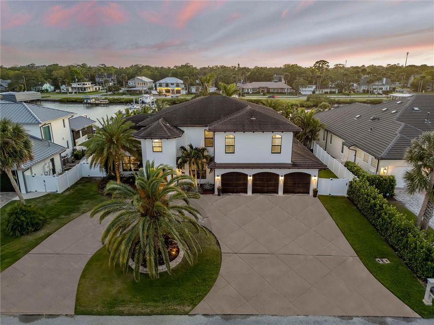 Welcome to 1212 Commodore Dr — a rare opportunity to own in the exclusive, gated community of Yacht Club Island Estates in beautiful New Smyrna Beach! Nestled on a quiet gated waterfront neighborhood, this 4-bedroom, 5-bath home offers the perfect blend of privacy, comfort, and coastal living.

Step inside to an inviting, open floor plan with soaring ceilings, abundant natural light, and spacious living and dining areas — ideal for relaxing or entertaining. The kitchen offers plenty of storage, a breakfast nook, and views of the lush backyard. The split bedroom layout provides added privacy, while the primary suite features a walk-in closet and en-suite bath.

Step outside to your very own backyard retreat! The resort style pool is surrounded by tropical landscaping, creating the ultimate setting for relaxation or entertaining. The outdoor kitchen is fully equipped with a built-in grill, sink, refrigerator, and bar seating — perfect for weekend gatherings, sunset dinners, or quiet evenings under the stars.

Located in Yacht Club Island Estates — a private, gated enclave on the Intracoastal Waterway, and just minutes from marinas, beaches, and charming Canal Street dining & shopping. Golf cart friendly and perfect for boating enthusiasts, this sought-after neighborhood offers both security and a serene coastal lifestyle.
Don't miss your chance to live in one of best-kept secrets in New Smyrna Beach’s ONLY waterfront gated community!

This is Florida living at its finest — your dream home awaits!