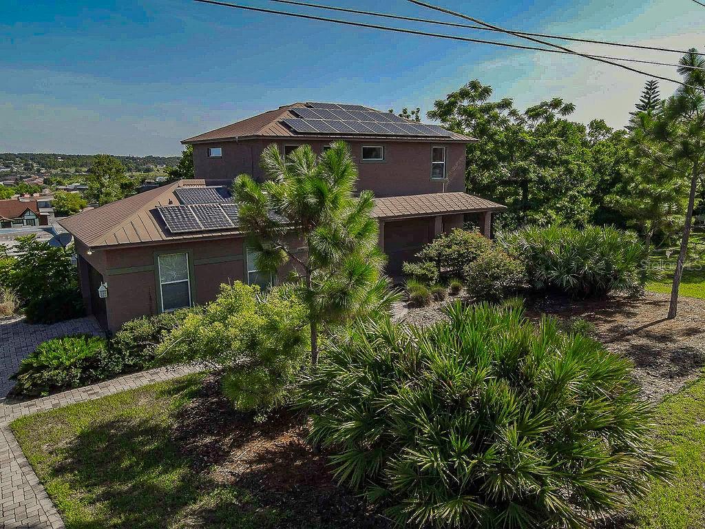 NATURE IN THE HEART OF LAKE WALES...If you love the elements of nature you will want to view this four bedroom, three bath property only minutes from Downtown or five-minute walk to Lake Wailes. Â From the half acre naturally landscaped lot with mostly indigenous drought tolerant plants to the stone paver driveway and walkways, entering this home under an expansive front porch there is one surprise after another. With numerous energy efficient features from windows to the metal roof with "owned" solar panels, including hybrid car charging station in garage you will be living "Green" and saving money monthly! Â Inside the welcoming foyer, you find amazing solid wood flooring flowing throughout with tiled kitchen and baths. Â The Open Floor Plan offers idea living space and with the treed views from the oversized windows, it feels like you're in a tree house. Â A fireplace wall enhances the beauty of the space with warmth from its stone facade. Â French doors lead out to the screened back porch which adds great dining and entertaining space. Â The first floor is completed with Kitchen and bath having gorgeous Corian countertops and wood cabinets. Â The first-floor bedroom or office has direct access to the full bath. Â On the second floor you find the spacious Master Bedroom with ensuite and walk-in closet. Â Again, with oversized windows offering magnificent views of Lake Wailes and the treetops. The Master bath is amazing with a huge walk-in shower, toilet closet and double vanity. Â Two additional Bedrooms, Full Bath, Laundry Room and Storage Closet complete the second floor. Â This property is minutes from downtown and the many festivals around Lake Wailes. Â Near medical, shopping and restaurants and centrally located between Orlando and Tampa, and just over an hour from either of Florida's coasts. Â You do not want to miss the opportunity to view this unique amazing property! Â Call today!