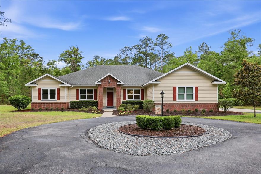 Welcome to this exceptional, custom-built, 5 bedroom, 3 bathroom, 3,008 sq ft saltwater pool home in Barrington Park, offering privacy, modern efficiency upgrades, and 5.62 acres of beautifully maintained land. No expense was spared in the design and build of this one-of-a-kind luxury homestead estate in northwest Gainesville. This property is equipped with an impressive list of upgrades including a 3-zone climate control HVAC system with smart thermostats, a whole-house dehumidification system, a new 80-gallon heat pump water heater (2024), a soft-start well pump (2023) with 5-year warranty, and a new drain field pump (2024). A whole house Tesla battery back-up system, powered by a 3.6 kW solar energy system with GRU net meter, keeps electric bills low and can power the entire home if the power goes out (better than a generator!). Concrete block construction, brick and Hardie plank siding, upgraded insulation and roof sheathing, a fully concrete block interior storm room, and impact-resistant storm windows and doors provide peace of mind and improved energy efficiency. All of this is found in a cozy and inviting home on 5+ acres of cleared and wooded land, where deer and other wildlife frequently visit. A private gated entry welcomes you as you arrive. Inside, you’re greeted by soaring 10 foot ceilings, engineered oak wood floors, crown molding throughout, and an open floor plan that blends style with functionality. The spacious and bright living room features a tray ceiling along with windows and french doors allowing for a gorgeous view of the pool and expansive backyard. The kitchen is sure to impress the chef in the family with its elegance and practicality, offering dark wood custom cabinetry, granite countertops, stainless steel appliances, built-in dual wall ovens, and a convenient eat-in space. You’ll also appreciate the additional storage of the walk-in pantry and a second refrigerator. The kitchen flows into the formal dining room, the perfect space for hosting friends and family for holidays or casual get-togethers. The spacious primary suite includes a large bedroom, two walk in closets, and an en-suite bathroom with dual vanity sinks, a soaking tub, and a separate tiled shower for a spa-like retreat. Four additional bedrooms and two more full bathrooms provide flexibility for family, guests, or a home office setup. The versatile 3-car garage, currently equipped with an EV charger, provides ample room for vehicles, storage, or a home gym. A designated laundry room and a mud room add everyday convenience with additional storage and workspace. Step outside to enjoy true Florida living. The screened patio overlooks the sparkling saltwater pool, while the expansive backyard offers a brick fire pit, a wireless pet fence system, and a thriving fruit and vegetable garden with irrigation. The smart lawn sprinkler system keeps the grounds lush with minimal effort. Once you visit this luxury homestead, you will never want to leave! This home is ideally located in NW Gainesville, zoned for Talbot Elementary, across the street from Turkey Creek Preserve ensuring peace and quiet, while also being just minutes from Publix and several local restaurants and shopping along NW 43rd St and NW 53rd Ave. Enjoy quick access to I-75, Santa Fe College, and major roadways for easy commuting throughout Gainesville, and just a 20 minute drive to UF. Schedule your private showing today!