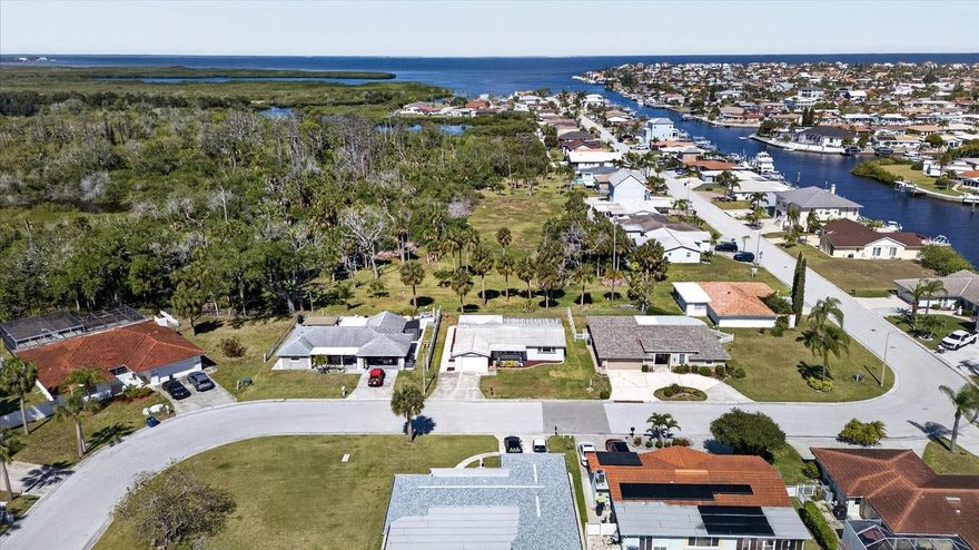 Location! Location! Location! Welcome home to this immaculate, beautifully remodeled home located in the highly coveted waterfront community of Gulf Harbors. Perfectly situated on a peaceful conservation lot, this property offers serene nature views, added privacy, and no rear neighbors. From the moment you walk into this move-in ready cottage, you will be wowed! A magical view of greenery and nature awaits; no rear neighbors except the eagles nest! This light and bright 1310 sq.ft., 2-bedroom, 2-bath, 1 car garage home features an inviting open-concept layout with a spacious living and dining area that flows seamlessly into the kitchen and breakfast nook. The updated kitchen showcases white craftsman-style cabinetry, granite countertops, a convenient eat-in bar, all new appliances and stylish stone-look tile flooring that enhances the home’s coastal charm. Over $115,000 in upgrades and improvements have been completed since 2020, including an additional $57,000 renovation in 2025. Recent updates also include upgrading a flat roof to a new angled roof over lanai, upgraded electrical panel, water heater, interior and exterior paint, new fencing, refreshed screens on the oversized screened porch, and beautiful brick paver walkways with an expansive 700 sq. ft. patio—perfect for outdoor entertaining or relaxing while enjoying the tranquil conservation views. Gulf Harbors offers an incredible Florida lifestyle with optional access to two private boat ramps, a private beach club, and an active civic association. Membership to the  private, gated, residents ONLY Gulf Harbors Beach Club is optional for just $200 a year which includes a 1/4 mile of white sandy beaches, chairs, cabanas, grills, and beach bathrooms! The neighborhood is golf-cart friendly and conveniently located just minutes from historic downtown New Port Richey, where you’ll enjoy waterfront dining, local shops, breweries, entertainment, Sims Park, pickleball courts, fitness centers, and more. Experience resort-style living year-round in this move-in-ready coastal retreat. Come see your next home today!