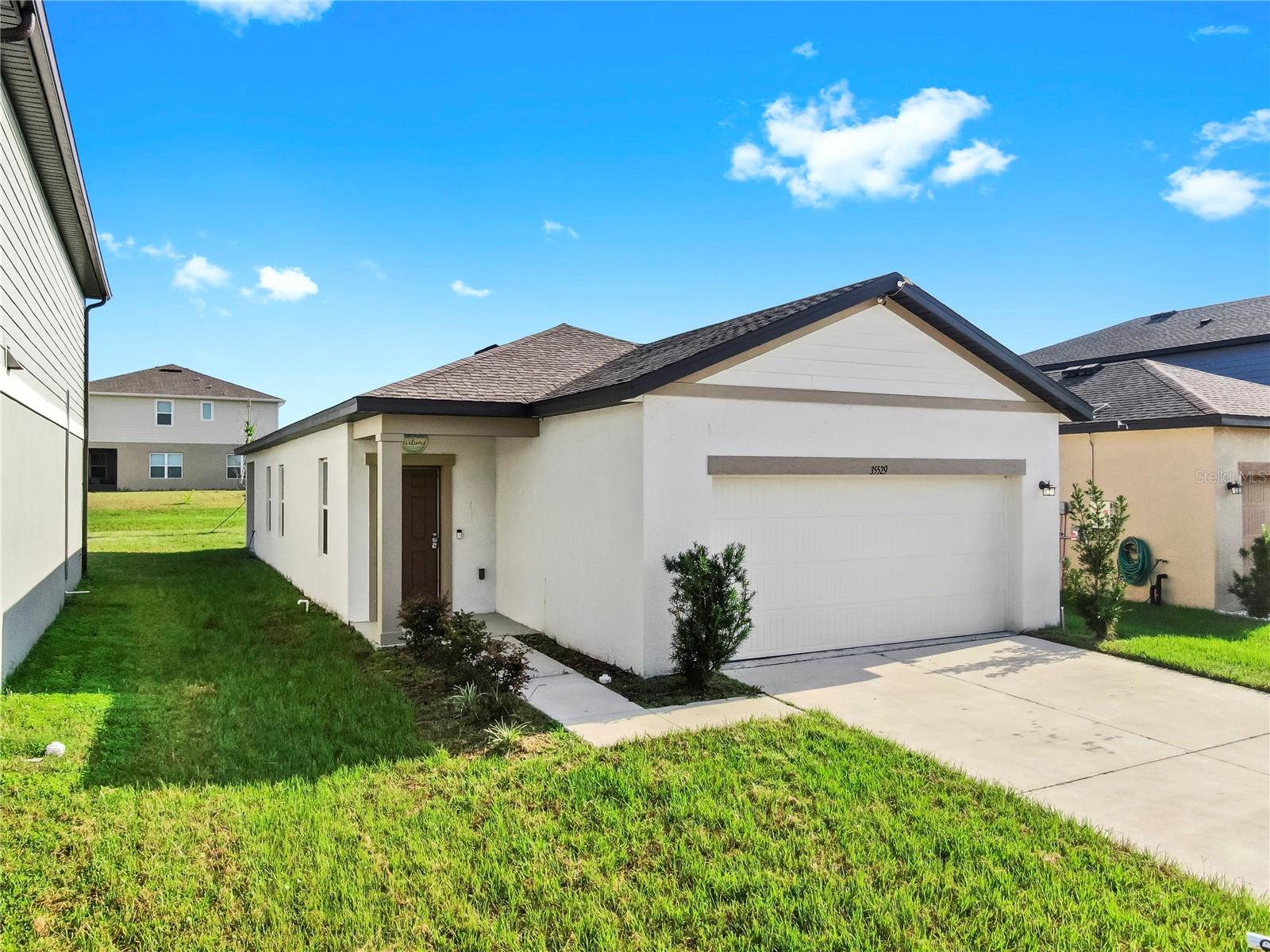 Welcome to your dream home in Zephyrhills!
This beautifully maintained 3-bedroom, 2-bathroom home was built in 2022 and offers 1,365 sq ft of modern, open-concept living. The bright and airy layout features a spacious living area that flows into a well-equipped kitchen with ample cabinetry and a convenient breakfast bar.
Enjoy a split-bedroom floor plan for added privacy, with a primary suite that boasts a walk-in closet and a luxurious en-suite bathroom with dual vanities and a walk-in shower.
Step outside to a covered patio and private backyard—perfect for relaxing or entertaining. Additional highlights include a 2-car garage, indoor laundry room, and access to a vibrant community with a resort-style pool, open-air clubhouse, playground, and dog park—all just 10 minutes from the Wesley Chapel lagoon.
Located close to shopping, dining, schools, and major highways, this move-in ready gem is ideal for families, first-time buyers, or anyone seeking low-maintenance Florida living.
Schedule your private showing today—this one won’t last!