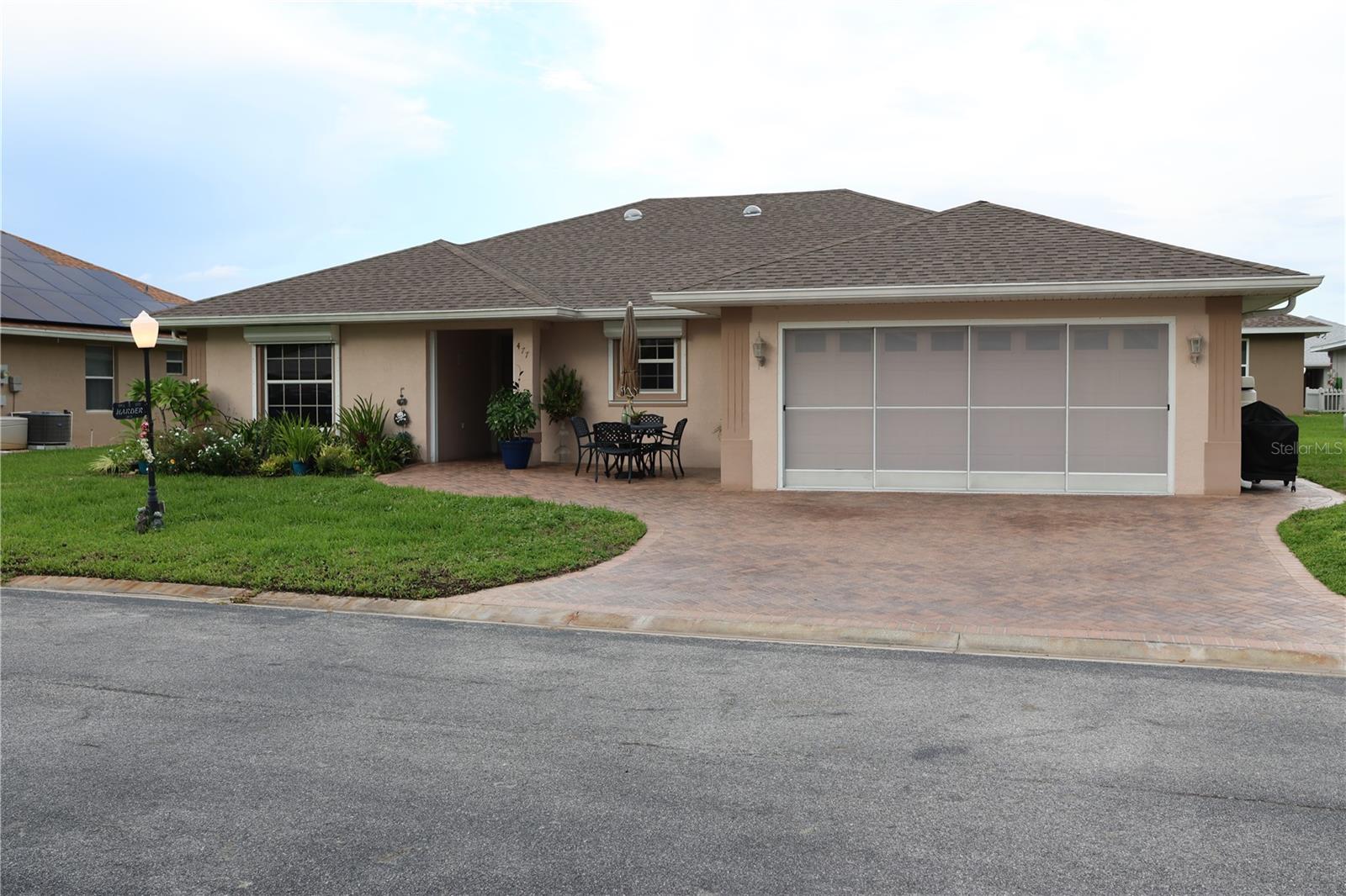 Welcome to lakeside luxury in this gated community of Lake Henry Estates, ideally positioned less than an hour from Walt Disney World, an hour to Tampa, and under 2 hours to either Florida coast! This beautifully maintained 3-bedroom, 2-bathroom split-plan home on concrete block construction offers the perfect blend of comfort and security. Storm-ready features include a whole home generator with dual 120-gallon LP tanks, professionally installed hurricane shutters and replaced roof and HVAC (2021). The spacious chef's kitchen showcases an extensive counter space, abundant cabinetry, and elegant ceramic tile flooring that flows throughout the main living areas, while plush carpeting adds warmth to the bedrooms. The primary suite features dual closet solutions, trey ceilings and a spacious tiled shower, creating your own private retreat. Beyond the two-car garage and paver parking, discover the true appeal of resort-style living with access to a 12,000 SF clubhouse featuring ballroom, heated pool and spa, 9-hole, executive golf course, tennis and pickleball courts, private pub, exercise facilities, woodworking shop, and boat dock on Lake Henry, plus RV and boat storage options. This active 55+ community combines tranquil lakefront living with convenient access to shopping and dining within 2 miles, including Publix, Walmart, and numerous restaurants. Experience worry-free Florida living where luxury meets security in one of Polk County's hidden gems.