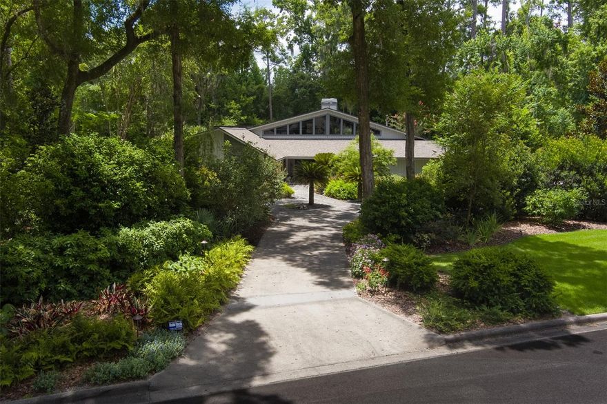 *** Elegant Retreat on Over an Acre Near the University of Florida ***

Located within the sought-after Hermitage neighborhood, this architecturally distinctive residence rests on 1.1 acres of beautifully landscaped grounds, offering a rare blend of scale, serenity, and convenience. Recently updated, the home seamlessly marries design-forward style with everyday comfort ~ ~ 

Through double entry doors, a light-filled interior unfolds with travertine floors, soaring ceilings, and walls of glass that blur the line between indoors and out. The expansive great room, anchored by a dramatic fireplace, transitions effortlessly across multiple living and entertaining spaces—including a striking custom bar with backlit quartzite—all overlooking the newly constructed (2025) resort-style pool and private backyard ~ ~ 

The chef’s kitchen is both refined and functional, featuring dual prep stations, a waterfall-edge island, induction cooktop, steam and convection ovens, and sleek custom cabinetry. The tranquil primary suite is a spa-like retreat with a soaking tub, oversized walk-in shower, and custom closet. A private secondary wing offers two bedrooms, a shared bath, a flex/media room, and a dedicated gym ~ ~ 

Main Home: 4,272 sq ft + 288 sq ft Studio Cottage // Total 5,581 sq ft under roof ~ ~ 

Recent upgrades include new flooring, impact-rated windows, and upgraded lighting designed to enrich ambiance and improve energy efficiency ~ ~ 

Outdoors, the screened pool area is a true showpiece with water features, a summer kitchen and grill room, a full pool bath, multiple patios, fountains, a striking fire table, and a putting green. Meandering garden paths wind through lush landscaping, fruit trees, and vibrant flowering gardens, leading to the detached 1BR/1BA Studio Cottage with kitchenette ~ ~ 

Exterior lighting was thoughtfully designed for versatility—providing a soft, elegant glow for everyday enjoyment while transforming into a colorful, dynamic display for festive gatherings ~ ~ 

Smart home integration and a state-of-the-art security system allow intuitive control of lighting, climate, sound, and surveillance. Additional highlights include a three-car garage, spacious laundry room, and concrete block construction—all just minutes from the University of Florida, top medical centers, and Gainesville’s premier shopping and dining