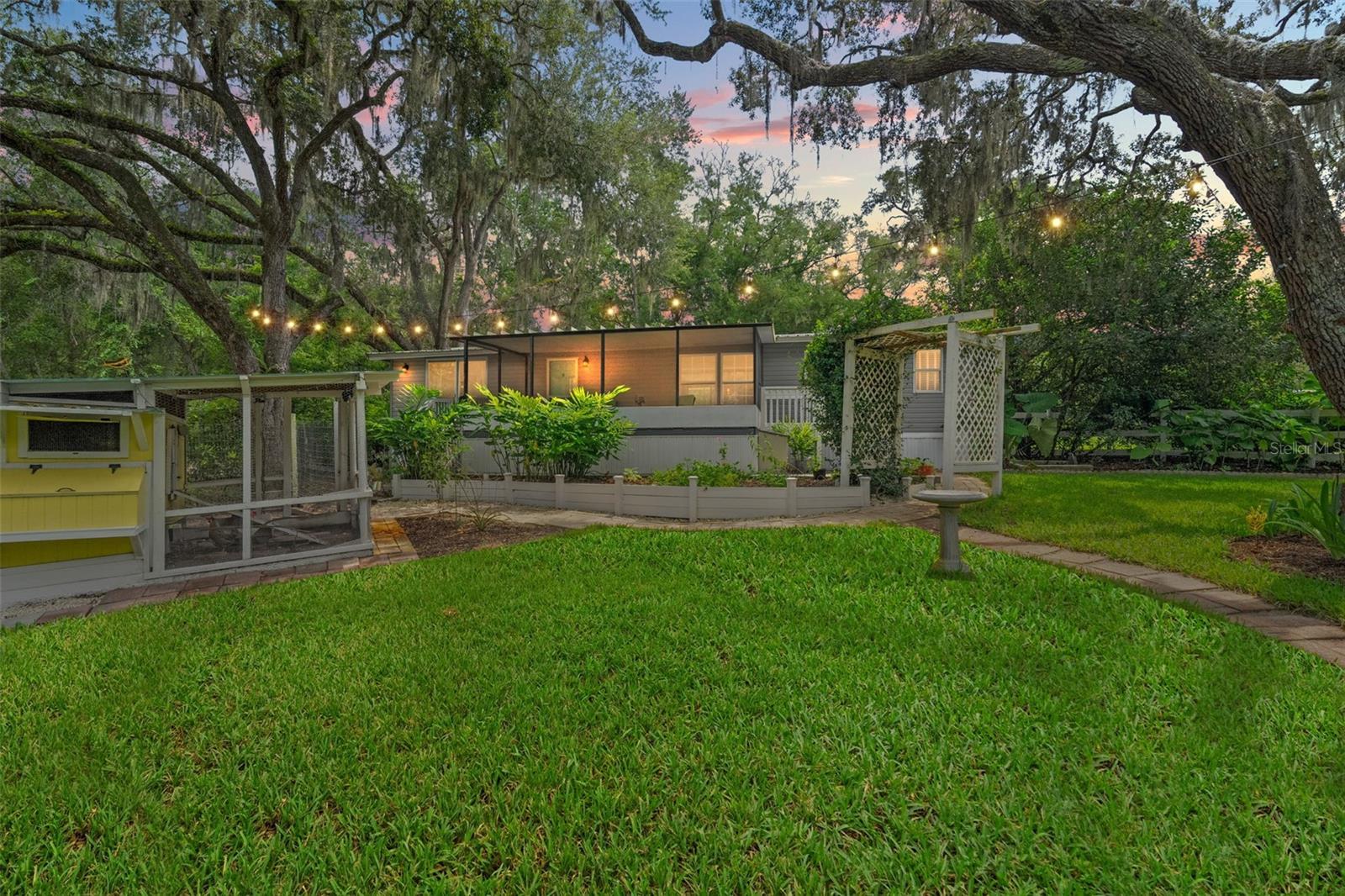Tucked away on just over 4.5 acres of peaceful, park-like land, this fully renovated 2-bedroom, 2-bath retreat blends modern comfort with the charm of a true homestead. Backing directly to 132 acres of Central Ridge Park and only steps from the 46-mile Withlacoochee State Trail, it’s the perfect setting for those who love the outdoors, dream of hobby farming, or simply crave a slower pace of life. Inside, the home feels brand new thanks to a top-to-bottom renovation — from the plumbing, electrical, insulation, and drywall to the custom finishes that add warmth and character. The kitchen is designed for both function and hospitality, featuring GE Profile appliances, a GE Monogram double oven, custom cabinetry, and a spacious wood-top island with clever storage touches like a built-in knife drawer. A walk-in pantry, cozy electric fireplace with a live-edge mantle, and even surround sound over the soaker tub make every day feel like a treat. Step outside and the property comes alive with endless possibilities. A 20x40 irrigated and fenced organic garden is ready for your vegetables and herbs, while the chicken suite with cameras and an automatic electric door makes tending to your flock a breeze. Towering granddaddy oaks and fruit trees provide shade and beauty, while the above-ground pool with turf surround and a screened-in outdoor hangout provide the perfect place to relax any day of the week. For projects, storage, or future plans, you’ll appreciate the 16x32 shed with water and electric, RV/boat slab, barn or storage slab, and even a shooting range. An electric gated entry adds both privacy and convenience. The innovative ProVista lawn keeps the grounds looking lush with minimal effort, thanks to built-in weed control. With room for an additional homesite, the possibilities here are endless. Whether you’re dreaming of a thriving garden, collecting fresh eggs each morning, entertaining friends under the stars, or simply soaking up the peace of Florida’s natural beauty, this homestead offers a lifestyle that’s both laid-back and deeply rewarding — all delivered in style. FURNISHINGS OPTIONAL.