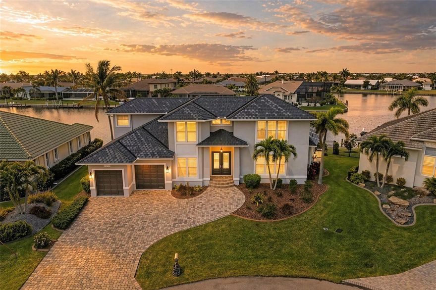 Welcome to a premier Gulf-access estate in the highly sought-after Burnt Store Isles—where luxury, scale, and waterfront lifestyle converge. Spanning over 4,900 square feet total, this expansive residence offers 4 bedrooms plus a den/loft, 3 full baths, and a thoughtfully designed layout ideal for both everyday living and grand entertaining.
Step inside to soaring 20-foot ceilings in the main living area, creating a dramatic yet inviting space filled with natural light. The open-concept floorplan is enhanced by tile flooring throughout the first level, solid core interior doors, and a full suite of storm protection including impact windows and doors, electric roll-down shutters, accordion protection, and a fully transferable flood policy for added peace of mind.
The chef’s kitchen is a standout feature, outfitted with a 6-burner Viking gas range, granite countertops, stainless steel appliances, soft-close cabinetry, and a breakfast bar—all flowing seamlessly into the dining area with panoramic views of intersecting canals.
The first-floor primary suite is a private retreat, complete with tray ceilings, French doors to the lanai, dual custom walk-in closets, and a spa-inspired bathroom featuring a jetted soaking tub and walk-in shower. An additional guest bedroom and full bath with direct lanai access are also located on the main level. Upstairs, a spacious loft overlooks the living area and is accompanied by two additional bedrooms, a full bath, and a private balcony capturing stunning water views! 
Outdoor living is nothing short of exceptional. Enjoy a heated pool with waterfall feature and spill-over spa, a well-appointed lanai with beverage bar, and retractable sunshades on both the lanai and balcony for year-round comfort. The meticulously landscaped and fenced yard leads to a 60-foot concrete dock equipped with water, electric, and a 16,000 lb boat lift—perfect for boating enthusiasts. 
Recent upgrades include a new Brava synthetic tile roof (2024) with transferable lifetime warranty, fresh exterior paint (2025), new pool pump (2025), and an 80-gallon water heater (2025). Plantation shutters throughout and an additional gas hookup for a generator add to the home’s functionality and appeal.
With western rear exposure, enjoy breathtaking sunsets nightly, and take advantage of quick boating access—just 30 minutes or less to Charlotte Harbor with no bridges. Optional membership to Twin Isles Golf & Country Club and proximity to Punta Gorda’s charming downtown, Fishermen’s Village, dining, shopping, and beaches complete the lifestyle package. Call for a private showing today!