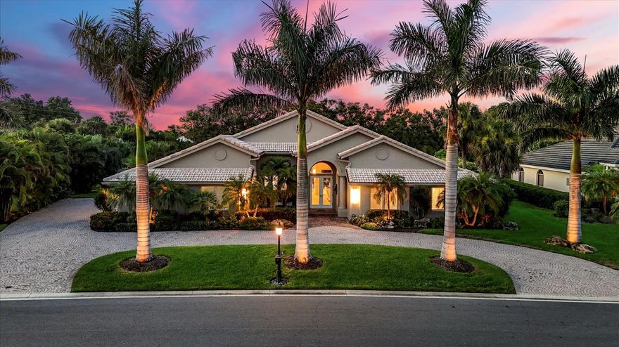 Set among soaring palms in the heart of The Estates of Prestancia, this 4-bedroom, 3-bath residence combines timeless curb appeal with a thoughtfully reimagined interior. A circular paver drive leads to a double-door entry, where high ceilings and open sightlines immediately introduce the home’s seamless connection to the lanai, pool, and water views beyond. Spanning 3,669 square feet, the home blends modern upgrades with effortless livability. Porcelain tile runs throughout, complementing dramatic ceiling heights and expansive entertaining spaces. The formal living room is anchored by a striking 100" LED fireplace, while adjoining the dining area and family room, offering a natural open flow into the heart of the home, a custom kitchen by Sheldon Campbell. Designed with entertaining in mind, the kitchen features central and serving islands, abundant storage, wall oven and microwave, a paneled refrigerator, a mirrored backsplash, a wine refrigerator, and an airy dining space overlooking the pool. The split-plan primary suite offers a private retreat with lanai access, vaulted ceilings, and polished tile floors, alongside a spa-like bath with dual vanities, a frameless glass shower with rainfall and handheld sprayers, and a dedicated tankless water heater. A hidden-entry guest suite with lanai access and en-suite bath provides a unique private haven, while two additional guest bedrooms share a bright, well-appointed bath. An office with built-ins, a spacious laundry room, and ample storage complete the interior. Outdoors, a resort-style lanai invites year-round living with imported shell stone pavers, a heated saltwater pool, an elevated spa, a sundeck, and a fully equipped outdoor kitchen. Lush landscaping creates privacy, while updates, including impact glass, two newer HVAC systems, a generator, irrigation, and drainage upgrades, and fresh paint inside and out, ensure peace of mind. A side-entry two-car garage completes the offering. In Prestancia, residents enjoy optional TPC memberships with golf and social opportunities, plus convenient access to The Legacy Trail, Siesta Key Beach, downtown Sarasota, St. Armands Circle, and the barrier islands. Blending thoughtful renovations, custom details, and seamless indoor-outdoor living, this Prestancia estate offers a move-in-ready lifestyle in one of Sarasota’s premier gated golf communities.