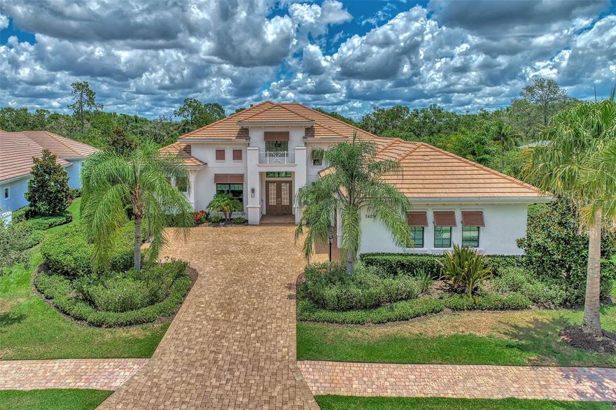 Located in the highly sought after gated community of Country Club East, this modern and stylish residence offers the perfect blend of comfort and sophistication. The former Gardenia II model by Stock Homes backs up to a picturesque preserve offering a serene and private setting. The thoughtfully designed open concept kitchen, living room and dining area, with soaring 14 foot ceilings and ceramic tile flooring throughout, is ideal for entertaining family and friends. Grandeur and elegance abound the main living space of the home. The great room features endless upgrades, including crown molding, double coffered ceilings, sophisticated designer lighting, custom window treatments and a built-in wall feature.  Your eye will be instantly drawn to the custom built 90-bottle glass-enclosed wine wall in the dining space. The gourmet kitchen features a massive 7’ x 10’ island, quartz countertops, gas cooktop, ample cabinet space and a walk-in pantry. Sliding pocket doors span the back of the home, adding abundant natural light to the living space and creating a seamless transition between indoor comfort and outdoor serenity.
The master suite is a retreat unto itself, offering a private alcove entry, two walk-in custom closets, a spacious bedroom and sitting area with glass French doors open to the oversized screened lanai.  A sweeping hallway leads you to the spa-like luxury master bathroom featuring an oversized (4.5’ x 10.5’) walk-in shower with floor to ceiling tile, two separate vanities, a free-standing soaking tub and a linen closet. Three guest bedrooms are en-suites with expansive closets, providing comfort and privacy for family and visitors.  The well-appointed, stylish office, which features a soaring 12-foot custom wooden coffered ceiling, motorized blinds with custom window treatment and french doors, caters to your work-from-home needs. Just when you think you’ve seen it all, stroll down the rear hallway to a hidden oasis. The versatile, oversized family room, which features pocket sliding doors to the lanai, tray ceiling, custom drapery and motorized blinds, embodies a cozy feel perfect for a weekend movie night or just snuggling up with a good book.  Freeform pool featuring sun shelf, integrated spa and two gas fire bowls with a waterfall feature. The granite topped outdoor kitchen with large island outdoor, equipped with a built-in gas grill, sink and beverage refrigerator. Enjoy a night of evening fun with integrated lighting and bistro lights in the back area, perfect for a family cornhole tournament. 
Additional features include laundry room that is functional with tons of cabinet space, sink, water softener and water filtration systems, hurricane impact glass throughout.  State-of-the-art smart home technology including two smart thermostats, smart entry lock, home security and camera system which can all be remotely controlled. Located a short distance to the neighborhood clubhouse which includes a community room, the newly appointed gym and the largest of three community swimming pools. The neighborhood is also home to several of Lakewood Ranch Country Club’s facilities, including one of its 4 golf courses, a driving range, clubhouse restaurant and pickleball courts.  Club membership has availability for a limited time following its recent 3-year waitlist. This home is centrally located and a short drive to University Town Center shops and restaurants also, nationally ranked beaches and A rated public schools.