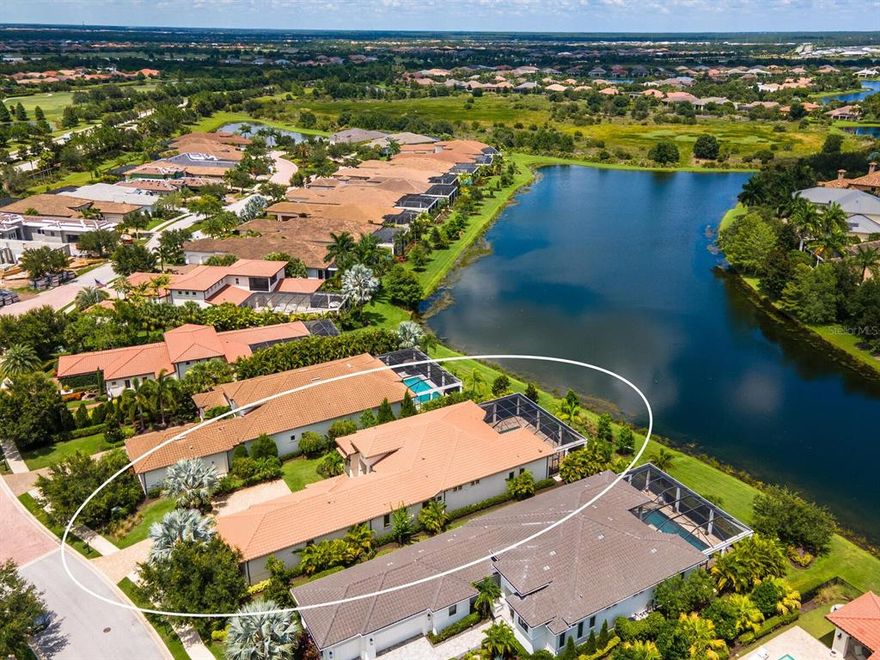 Welcome to this luxurious waterfront home, in desirable Matera neighborhood in The Lake Club at Lakewood Ranch. Once inside you'll feel like you've stepped into your own private sanctuary, surrounded by lush, well manicured landscaping. This 2018 Lee Wetherington-built Certified Green Home has impact doors and windows throughout, and provides maintenance-free living, including grounds and pool service. The craftsmanship of this home is impeccable, with elegant upgrades and designer details at every turn. Inside, you’ll find exquisite white oak flooring and volume ceilings, as well as architectural details such as crown molding, coffered ceilings, LED recessed lighting, custom window treatments, fans, light fixtures, outdoor landscaping lighting, whole-house water softener and Control 4 including upgraded security system. The beautifully appointed kitchen includes a large center island, quartz countertops, designer glass tile subway backsplash, white wood cabinetry, Sub-Zero refrigerator, Wolf six-burner cooktop, built-in convection oven and huge pantry. The 45’x 46’ lanai  is perfect for entertaining and dining, with it's travertine deck, heated saltwater pool/spa, and outdoor kitchen with granite counters, refrigerator and hood. Soak in the sun on the pool’s sun shelf, while savoring gorgeous views of the glistening lake and flourishing tropical landscaping. A serene retreat awaits in the owner’s suite, which offers two customized walk-in closets, coffee station, wine refrigerator, sitting area and double doors to the lanai. The spa-like bath features dual vanities, quartz counters, an oversized shower, freestanding tub and designer glass tile detail. This fabulous home also has two guest bedrooms with well-appointed en-suite baths as well as double French doors leading to the Den/Office.  The Lake Club community includes a clubhouse, restaurant, pool, tennis, playground, basketball and fitness center, and is close to shopping, dining and I-75.