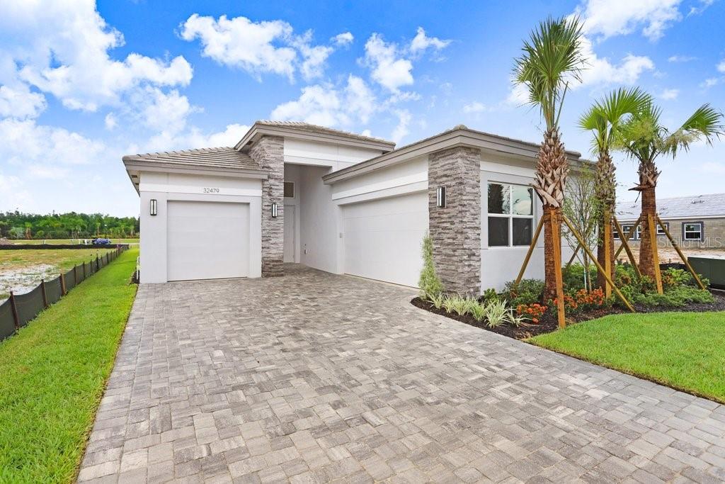 BRAND NEW | LUXURY 55+ LIVING IN VALENCIA RIDGE! Be the first to live in this stunning, brand-new 3BR/3BA + Flex Room single/offic family home located in the premier 55+ gated community of Valencia Ridge in Wesley Chapel. This never-lived-in home offers 2,364 sq. ft. of elegant living space with designer upgrades throughout and a 3-car garage perfect for vehicles, storage, or a golf cart.
Enjoy a gourmet kitchen featuring quartz countertops, upgraded Samsung stainless steel appliances, a large center island, and stylish pendant lighting. The open-concept layout flows into a spacious great room and a casual dining area, leading out to a covered extended lanai with paver flooring ideal for relaxing or entertaining. The private primary suite includes a spa-style bathroom with dual vanities, an oversized walk-in shower, and two walk-in closets—the flex room is versatile as a home office, den, or guest space. As a resident, you’ll enjoy world-class amenities: a resort-style clubhouse, fitness center, pools, spa, pickleball courts, walking paths, and vibrant social clubs. Conveniently located minutes from Wiregrass Shops, AdventHealth Hospital, and major highways. Lawn maintenance included. One resident must be 55 or older. Available for immediate move-in. Schedule your private tour today and experience luxury living at its finest!
