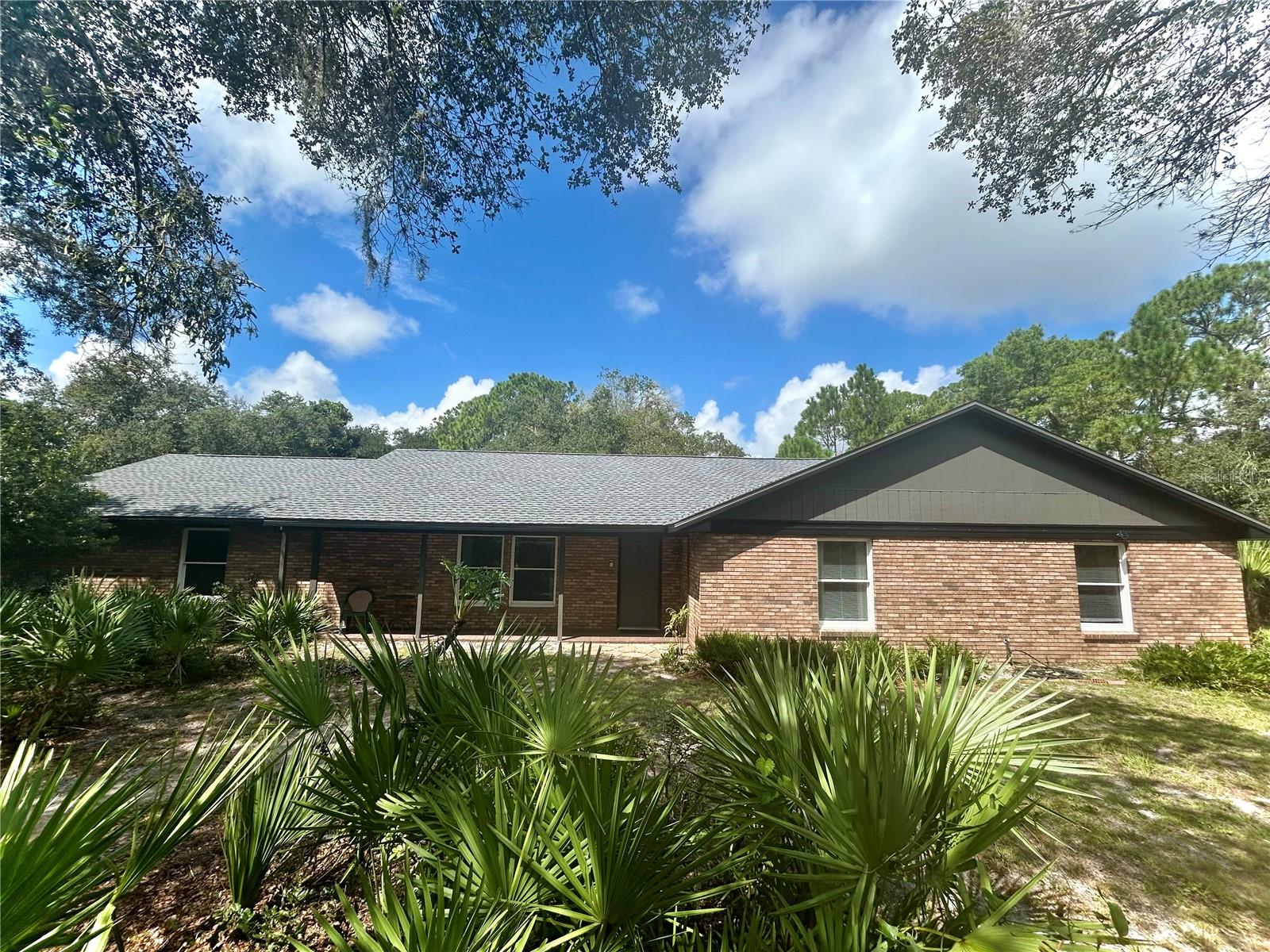 This private residence, set on 2.8 acres, features a brand new roof installed in August 2025. The brick single-family home offers 2,250 square feet of living space, conveniently located with no HOA restrictions. It includes four spacious bedrooms and two bathrooms. Plenty of room on this large parcel. Screened porch for your outdoor enjoyment. The interior boasts wood floors throughout and is equipped with stainless steel appliances, providing both style and functionality. Additionally, there is ample space for parking your RV, boat, and other recreational vehicles.