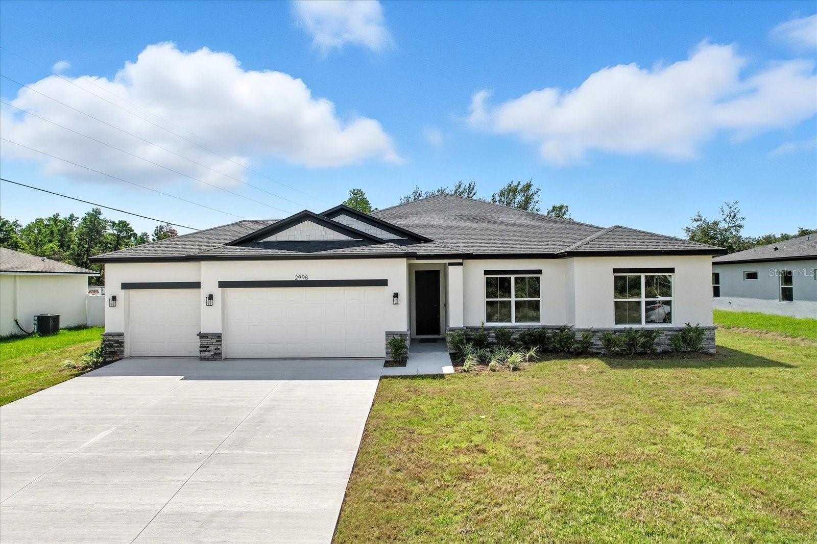 Ask about our Builder Incentives including interest rate buydown and closing cost assistance! Impeccably designed BRAND-NEW CONSTRUCTION 4-bed 3-bath-3-Car Garage home located in Marion Oaks with close proximity to everything Ocala has to offer! From the moment you arrive you will notice the difference. You are greeted by the oversized driveway, stacked stone accents, and volume 9'4'' ceilings throughout the entire home. The main living space is centered around the Living Room with stunning 8' triple panel sliding glass door that overlooks the covered lanai which perfectly integrates the indoor/outdoor living space. The kitchen showcases Dolce White Quartz countertops, Samsung stainless steel appliance suite, 42'' upper cabinets with soft-close, entertaining island, and French doors with additional access to the cover lanai. Owner's Suite features trey ceiling, oversized dual sink vanity, stunning designer shower with glass enclosure, and his & hers walk-in closets. All guest bedrooms are well sized with ample closet space. The private Guest Suite has an en-suite bathroom making it perfect for a Guest room or JR. Suite. Both Guest bathrooms feature tub/shower combo with floor to ceiling tile as well. Spacious Laundry room with an additional linen closet for added storage, plus the washer and dryer are included in the sale! Don’t miss your opportunity to make this house your HOME…Schedule your private tour today!