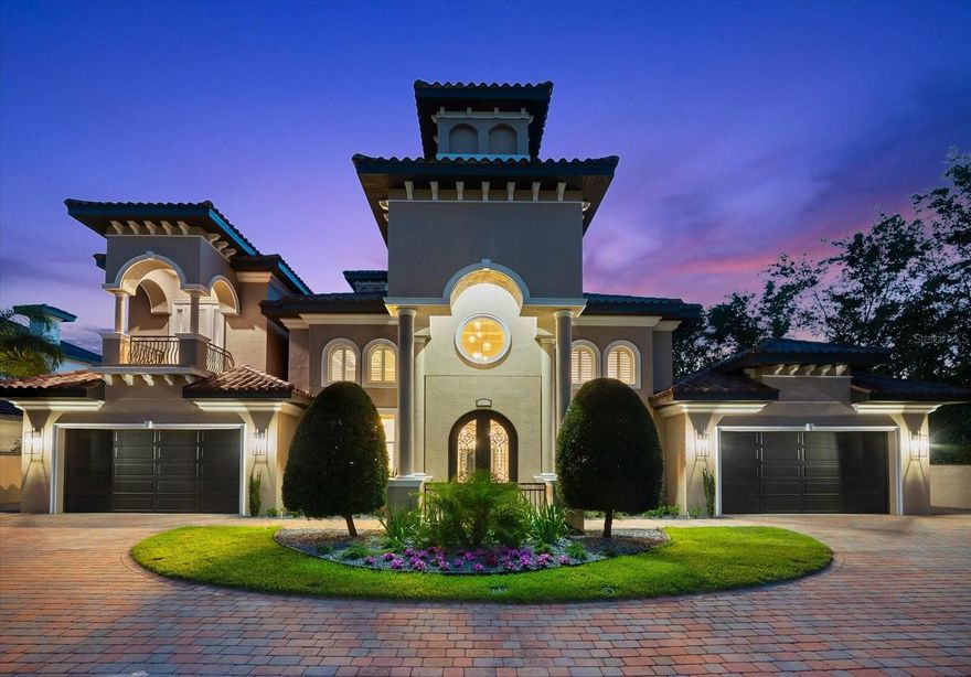 Behind the private gates of this distinguished Belleair estate lies a rare fusion of architectural sophistication and modern luxury. Offering over 6,000 square feet of meticulously designed living space, this custom-built residence is a testament to timeless craftsmanship and refined living. As you approach, an expansive circular paver driveway and four-car garage welcome you with stately grandeur. The moment you enter through the custom double doors, you're greeted by a dramatic foyer with soaring ceilings, stately columns, 8-foot doors, and rich tumbled marble flooring. A sweeping wrought iron staircase sets the tone for the elegance that unfolds throughout the home. The grand two-story family room captivates with floor-to-ceiling windows that bathe the interior in natural light, a gas fireplace framed by intricate millwork, and a bridged balcony connecting the home’s East and West wings—all overlooking the lush, manicured grounds and resort-style pool. Every space is designed with intention, offering both comfort and class in equal measure. The heart of the home—the chef’s kitchen—was completely reimagined in 2023 with bespoke finishes and top-of-the-line appliances. A large center island, butler’s pantry, custom cabinetry, and elegant quartz surfaces create a functional yet striking culinary space designed for both intimate dining and large-scale entertaining. The first-floor primary suite is a true sanctuary, tucked away for privacy and designed to rival any five-star resort. Featuring a spa-inspired en-suite bathroom with a walk-through shower, jacuzzi tub, dual vanities, and spacious custom closets, this retreat invites rest and rejuvenation in complete privacy. Upstairs, four additional bedrooms and two oversized bonus rooms present endless flexibility—ideal for a home office, gym, media lounge, or additional guest suites. A second-story veranda provides tranquil views of the lush backyard and sparkling pool, with a spiral staircase leading gracefully down to the patio below. Step outside to your private oasis: a 24,000-gallon heated saltwater pool, surrounded by tropical landscaping and powered by a state-of-the-art Hayward OmniLogic system for full automation and custom ambiance. The fully equipped outdoor kitchen makes alfresco entertaining effortless, while block fencing and wrought iron detailing ensure privacy without compromising beauty. Additional features include two tankless water heaters, a newly installed main gas line, water softener, and reverse osmosis system. No expense was spared and no detail overlooked in the curation of this extraordinary property. Set on a premier lot in one of Belleair’s most coveted enclaves, this estate offers unmatched luxury in a coveted location—minutes from championship golf, award-winning beaches, boutique shopping, and fine dining. An exceptional offering for those who demand the very best.