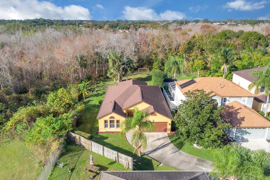 Welcome home to a property that offers peace, privacy, and thoughtfully designed spaces inside and out. Tucked away at the end of a quiet cul-de-sac, this Sanford home sits on one of the most desirable lots in the neighborhood, bordered by conservation land on multiple sides for a rare sense of openness and tranquility. With minimal traffic and only one neighboring home, separated by a natural privacy screen of bottlebrush hedge and exotic bamboo, the setting feels exceptionally serene.
Inside, an open and spacious floor plan is filled with abundant natural light and enhanced by vaulted ceilings, architectural arches, and plant shelves that add character throughout. High-end waterproof laminate flooring with a 25-year warranty flows through the main living areas, complemented by new carpet in all bedrooms and tiled bathrooms with brand-new toilets. The kitchen features stainless steel appliances less than five years old, selected for quality and durability, and offers ample space for a cozy eat-in area while remaining open to the main living spaces, perfect for both everyday living and entertaining.

French doors lead to the oversized screened-in, tiled porch, finished with beautiful Spanish tile that matches the upgraded paver entry walkway at the front of the home. This exceptional outdoor living space easily accommodates dining and lounging furniture, or even a ping-pong table, and includes two ceiling fans to keep you comfortable during the warmer months. With an outdoor area like this, it’s easy to imagine spending most of your time right here.

The spacious primary suite features a well-appointed bath, garden tub, and separate shower. Additional highlights include a roof replaced in 2015 with 7 to 10 years left, exterior paint completed approximately five years ago, a super low HOA fee, an oversized two-car garage, and generous attic storage above the garage for excellent additional space.

Perfectly positioned in Sanford, this home is equally convenient to Historic Downtown Sanford and Colonial TownPark, and just 10 minutes from Downtown Lake Mary. The location is well connected to major highways including I-4 and 417, providing easy access to shopping, dining, and everyday conveniences throughout the Sanford and Lake Mary areas and beyond. Zoned for top-rated Seminole County Public Schools, this home delivers comfort, quality, and an exceptional setting - a rare find and ready for you to make it your own.