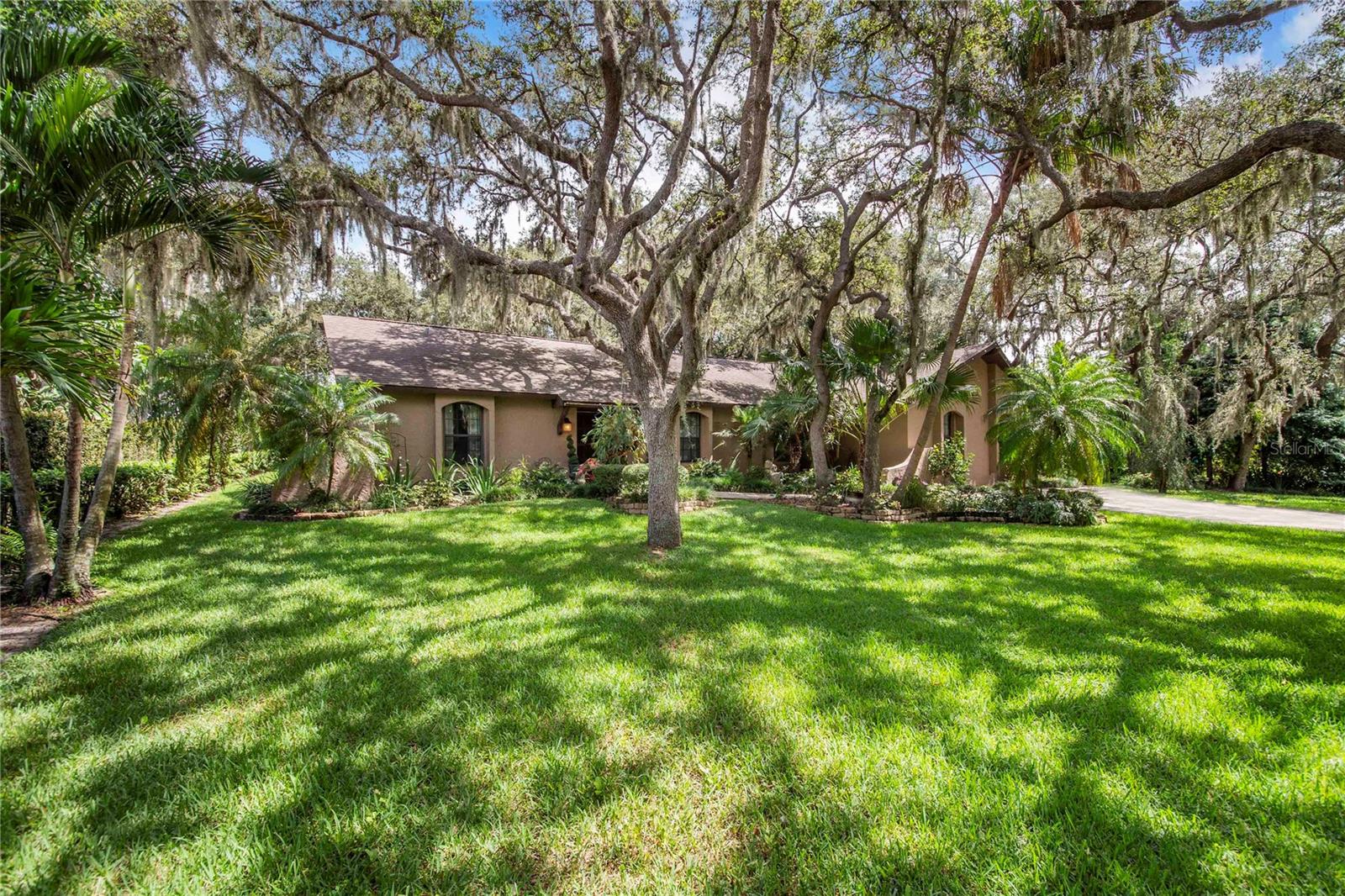 Discover this inviting 3-bedroom, 2-bath home featuring a screened saltwater pool and a thoughtfully designed split floor plan. The formal living and dining rooms provide elegant spaces for entertaining, while the family room offers comfort with an electric fireplace and stunning ceiling beams. Sliding glass doors open to an enclosed patio, seamlessly connecting indoor and outdoor living and leading to the pool area.
The kitchen showcases wood cabinetry, stainless steel appliances, and a cozy eat-in area, all accented by beautiful beams that add warmth and character. The master suite, conveniently located off the kitchen, includes a versatile bonus or great room with its own private entrance—ideal for a home office, guest suite, or studio.
Enjoy a lushly landscaped yard with mature oak trees and vibrant plants, plus a storage shed for added convenience. Situated on a quiet dead-end street, this home offers privacy and tranquility while remaining close to local amenities. Don’t miss your chance to own this exceptional property!