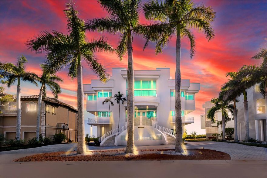 Positioned behind the gates of Esplanade on the Bay, this custom-built contemporary waterfront estate offers a rare opportunity to own 100 feet of private Sarasota Bay frontage with unobstructed, panoramic bay views from nearly every room. Floor-to-ceiling walls of glass and soaring 18-foot ceilings frame the water as living art, while imported granite tile flooring—installed by artisans known for their work at the Bellagio in Las Vegas—creates a refined, gallery-like interior. 
The expansive third floor was thoughtfully designed for luxurious grand-scale entertaining, offering an elegant and seamless flow that sets the stage for unforgettable gatherings beginning with the stately great room that anchors the home with dramatic bay vistas, flowing seamlessly into a sophisticated formal dining room, anchored by kitchen and a custom wet bar with built in ice maker. This gourmet chef’s kitchen is impeccably appointed with an elite suite of Thermador, Sub-Zero, Bosch, and Dacor appliances, complemented by an oversized statement island, an inviting breakfast bar, and a dedicated wine cooler. An expansive separate scullery kitchen with a second set of deluxe appliances provides discreet prep space and seamless catering flow—elevating every gathering with true estate-level sophistication. 
The Primary Bedroom suite is a true sanctuary, complete with a romantic fireplace and a spa-inspired bath featuring a glass-encased shower, a jetted soaking tub, and indulgent designer finishes. Expansive custom walk-in closets and elevated terraces capture sweeping, panoramic bay views, creating an exquisite haven of comfort and sophistication—while a dedicated meditation room on this level provides a serene space for reflection and renewal.

The second floor features three exceptional bedroom suites, each offering refined, private accommodations with a luxurious en-suite bath and its own balcony overlooking the shimmering bay—creating a serene retreat. This level includes an inviting family room anchored by a statement fireplace, a dedicated private study, and culminates in a fully outfitted home theater with plush luxury seating for eight.
The heated gunite pool and spa, enclosed for comfort and equipped with self-cleaning technology, is complemented by an outdoor kitchen making it ideal for sunset entertaining. A private dock extends from the estate’s 100 feet of direct waterfront, complementing the home’s uninterrupted sightlines across Sarasota Bay.
Modern luxury blends seamlessly with smart sustainability and refined practicality. Rooftop solar panels generate approximately 70% of the estate’s energy, while a private elevator serves all three levels and the rooftop retreat. Newly installed hurricane-rated garage doors add security and peace of mind.
For the discerning collector, a six-car garage with dedicated workshop space, complemented by a gracious circular drive, offers exceptional capacity and an impressive arrival experience for residents and guests alike.
Located minutes from IMG Academy, Sarasota-Bradenton International Airport, world-class dining, upscale shopping, and the barrier island beaches of Anna Maria Island and Longboat Key, this custom Sarasota Bay waterfront estate represents a rare convergence of scale, architectural significance, and unobstructed bay views—crafted for discerning buyers seeking a premier Gulf Coast luxury residence with privacy and enduring value.