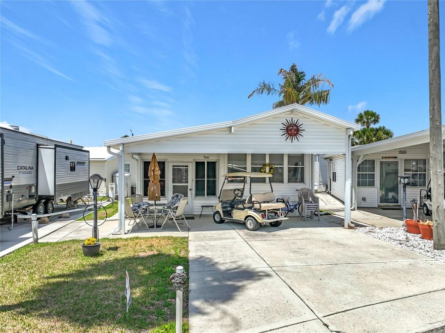 Charming 1-bedroom, 1-bathroom home ideally located just a short distance from one of the community’s pools in the highly sought-after gated lakefront community of Outdoor Resorts at Orlando. This well-maintained property offers comfortable Florida living with several thoughtful upgrades throughout.  The home features a bright Florida room with new sliding windows, creating a versatile space to relax or entertain year-round. Additional highlights include convenient interior stair storage, a 2-car driveway, and a newer carport for added functionality and protection.  A wide side walkway leads to a private rear patio, complete with a patio set and barbecue grill—perfect for enjoying the Florida sunshine or hosting family and friends.  Outdoor Resorts at Orlando offers an exceptional lifestyle with resort-style amenities including two large heated pools, a heated kiddie pool,  playground, lighted tennis courts, pickleball, shuffleboard, a par-3 golf course, mini golf area, volleyball court, basketball court, bocce ball, and horseshoes.  For water enthusiasts, the community provides access to Lake Davenport with a private boat ramp, allowing for boating, jet skiing, water skiing, and fishing. The clubhouse features a library, lounge for socializing or card games, and a spacious auditorium for community events and activities.  This is a fantastic opportunity to enjoy resort-style living in a vibrant, amenity-rich community close to everything Central Florida has to offer.