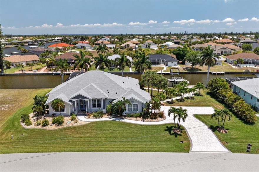 LUXURY WATERFRONT LIVING IN SOUTH GULF COVE WITH STUNNING INTERSECTING CANAL VIEWS! Welcome to this BEAUTIFULLY DESIGNED 4 BEDROOM, 3 BATHROOM, 2 CAR GARAGE POOL & SPA HOME perfectly positioned on an OVERSIZED DOUBLE LOT with approximately 184 FEET OF WATER FRONTAGE along the ROSEBUD WATERWAY. Surrounded by lush tropical landscaping and showcasing breathtaking WIDE WATER VIEWS, this property offers the ultimate blend of elegance, comfort, and the Florida boating lifestyle.

From the moment you step inside, you’re greeted by an OPEN, LIGHT-FILLED FLOORPLAN designed to maximize both space and waterfront scenery. Expansive 90-DEGREE POCKET SLIDERS create a seamless indoor-outdoor living experience, opening the home to the spectacular lanai and pool area while framing picturesque intersecting canal views from multiple living spaces.

Designed for both entertaining and everyday luxury, the home offers multiple gathering areas including a spacious family room highlighted by elegant tray ceiling details and a cozy fireplace that creates a warm, inviting atmosphere. The AQUARIUM GLASS BREAKFAST NOOK provides a stunning backdrop for casual dining while overlooking the sparkling pool and waterways beyond.

The kitchen is beautifully appointed with GRANITE COUNTERTOPS, STAINLESS STEEL APPLIANCES, attractive cabinetry, tiled backsplash, and ample prep space—perfect for hosting family and guests with ease.

The OVERSIZED PRIMARY SUITE serves as a private retreat with direct lanai access, allowing you to wake up to peaceful water views each morning. The SPA-STYLE ENSUITE BATHROOM offers generous space designed for relaxation and comfort. The LARGE WALK IN CLOSET with BUILT IN DRAWERS makes organization effortless. Spacious guest bedrooms provide flexibility for visitors and family, including a thoughtfully designed JACK-AND-JILL BATHROOM setup for added convenience.

Step outside to your private RESORT-STYLE OUTDOOR OASIS featuring a HEATED POOL AND SEPARATELY HEATED SPA—ideal for year-round enjoyment. The expansive lanai and waterfront setting create the perfect place to entertain, unwind, and enjoy Southwest Florida sunsets. Boating enthusiasts will appreciate the LARGE DOCK and 10,000 LB BOAT LIFT installed in 2024, providing effortless access to the Gulf of Mexico and endless waterfront adventures.

Major updates provide peace of mind, including a NEW ROOF (2022), NEW POOL PUMP (2022), and NEW 5-TON A/C SYSTEM (2021).

Located in the highly desirable SOUTH GULF COVE community, this exceptional property is just a short drive to Gulf beaches, golf courses, waterfront dining, shopping, parks, and world-class fishing.

This is more than a home—it’s a WATERFRONT LIFESTYLE EXPERIENCE. Schedule your private showing today and discover everything this extraordinary property has to offer!