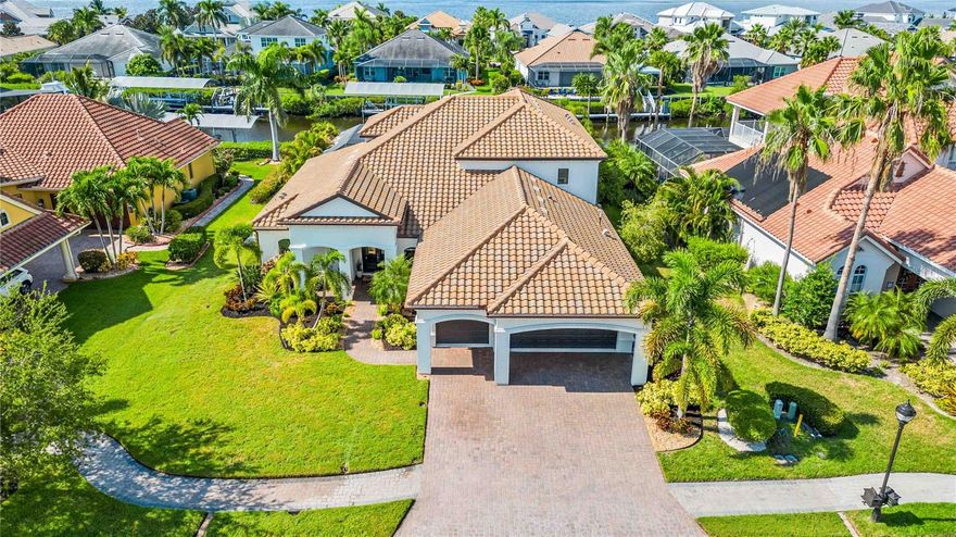 BACK ON MARKET - Due to reasons unrelated to the property or sellers. Come experience the allure of this waterfront home and its' coastal contemporary design in Harbour Walk at The Inlets. Harbour Walk is an exclusive gated waterfront community, showcasing stylish, custom-built waterfront homes developed by award-winning homebuilders. It is a neighborhood that embraces nautical luxury living and fosters a strong sense of community. 

This exquisite property is perfectly situated on a deep saltwater canal, offering direct access to the Manatee River and Gulf of Mexico. Prepare to embark on a lifestyle of unparalleled relaxation, entertainment, and natural beauty.

Meticulously maintained, this home radiates elegance and at every turn, spanning nearly 3900 square feet. As you step outside, envision yourself cruising down the canal on your boat, basking in the warm sun and cool breeze. Catch the freshest fish, and bring your delightful catch back to the outdoor kitchen, where you'll effortlessly prepare a mouthwatering feast for your loved ones. Entertain friends and family in style as you gather around the pool area and patio, enjoying the idyllic waterfront setting.

As the day draws to a close, experience the magic of the evening. The outdoor fireplace casts a warm glow, creating a cozy atmosphere as you gather with your loved ones for sunset views and indulgent al fresco dining. Watch in awe as playful manatees gracefully glide through the canal, adding a touch of wonder to your surroundings.

Inside, the home welcomes you with open arms and breathtaking views. The kitchen, overlooking a spacious great room and dining area, becomes the heart of the home. Adorned with an oversized island, it invites culinary creativity and serves as a gathering place for unforgettable moments. A large pantry room ensures ample storage, catering to your every need.

The lower level boasts the primary suite, offering a private sanctuary where you can unwind and rejuvenate. Additionally, you'll find a den and one of the bonus rooms, providing versatile spaces to suit your lifestyle. Ascend to the upper level, and you'll discover three additional bedrooms, one being an en-suite, and an additional bathroom, all connected by a large bonus room.  As you step outside one of the additional bedrooms onto the balcony you are greeted by captivating water views that will leave you breathless. 

Situated within close proximity to an array of amenities, you'll find everything you need just a stone's throw away. Explore the vibrant dining and shopping scene, indulge in world-class golf courses, or take advantage of the nearby marinas for all your boating needs. With easy access to major highways and airports, commuting and travel become effortless, ensuring that you're always well-connected to the rest of the world. 

Harbour Walk is an exclusive gated waterfront community, showcasing stylish, custom-built waterfront homes developed by award-winning homebuilders. It is a neighborhood that embraces nautical luxury living and fosters a strong sense of community. 
Please refer to feature sheet for additional information. Inspection report available upon request. Room Feature: Linen Closet In Bath (Primary Bedroom).
