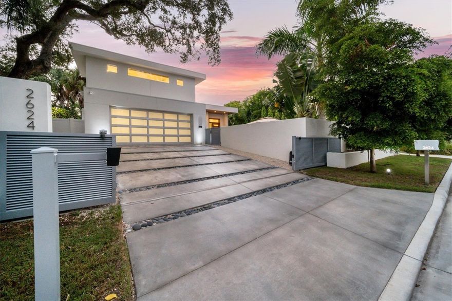 One or more photo(s) has been virtually staged. Award-winning architect Mark Sultana’s modern design, a highly desirable WEST of TRAIL location, and top-quality Voigt Brothers construction are just a few of the reasons this 5 bedroom, 5 bath, pool home built in 2021 is exceptional. Propped high on a charming street and not in a flood zone, this private and walled property opens to a large Palm Springs style terrace with saltwater heated Pebble Tec pool, spa, sun shelf and fire pit, perfect for cocktails and intimate conversation or entertaining a crowd. Enjoy the Florida lifestyle at its best in a bright and open floor plan with 13’ high ceilings flowing from the front door to the back patio through a wall of glass. Disappearing glass doors open to your private tropical back yard and summer kitchen- with plenty of room to entertain, dine, throw a ball or play with the dog. The living room floor-to-ceiling accent wall features an electric fireplace and is flanked by floating solid oak shelves with undermount lighting. A sleek chef’s kitchen is centered on a dramatic 14-foot double thick island with waterfall and seating space for six. Five ultra-premium DACOR appliances are complemented by solid wood custom cabinetry, with, a wine cooler, and variable accent lighting. The dining room has 10’ windows overlooking the pool terrace and is discretely separated from the kitchen by an accent wall with LED lighting. The first-floor owner’s suite has a glass door to the terrace, two walk-in custom closets, a spa shower, freestanding tub, separate water closet and a floating vanity with undermount lighting. The second floor features a loft office, and two bedrooms including a second primary suite. Also on the second level is a large flex room with full bath and walk in closet, a wet bar, surround sound and an AV closet-perfect for a media room, another large bedroom or playroom. You’ll find the 5th bedroom on the first floor along with a bathroom, and a large laundry room with utility sink, storage and garage access. The owners spared no expense equipping this home: wide plank French oak hardwood floors, cypress wood outdoor ceilings, a 20 KW Kohler whole-house generator supplied by two propane tanks which are also connected to the 2 tankless water heaters, the kitchen stove and pool heater. Two 15 SEER HVAC units. All concrete surfaces have a non-slip coating. There’s a privacy wall and fence, a motorized security gate, impact windows, doors and an impact garage door all connected to a Smart home system which also controls lighting, sound, TVs, window shades, cameras and the pool. Commercial grade membrane roof. This is a fabulous meticulously crafted residence located minutes from world-renown Siesta Key Beach, quaint Southside Village, downtown dining, galleries and boutiques and the rich cultural life of Sarasota with opera, ballet, theatre and festivals in a charming city of 58,000. You will be two blocks from an adorable playground at one of the highest rated elementary schools in the district. Don’t miss out! WATCH THE VIDEO!