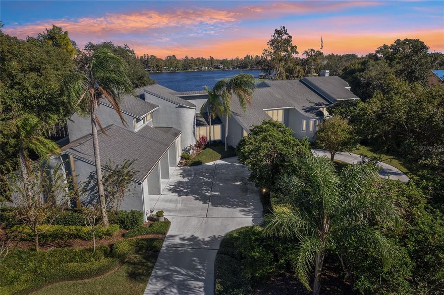 Welcome to this amazing lakefront estate in Avila, Tampa Bay’s Premier, guard-gated, golf and country club community! This residence is one of only a handful of estates in Avila that are located on Lake Chapman, the only ski size lake in Avila. The property unfolds with awe-inspiring panoramic waterfront vistas and meticulously landscaped grounds that enhance the beauty of this two-story home.Encompassing 8,270 square feet of air-conditioned living space, this residence boasts 5 bedrooms, 7.5 bathrooms, a home office, movie/game room, home gym, swimming pool, spa, dock, and a 3-car garage. As you step through the custom-designed front doors, natural light floods the interiors through abundant windows, creating an inviting atmosphere. The living and dining rooms, adorned with panoramic water views, which set the stage for elegant entertaining. The family room, coupled with an adjacent bar, provides a welcoming space to gather and unwind. The fireplace provides the central focal point in the family room and sliding glass doors lead to your outdoor paradise. The chef's kitchen features stainless steel appliances, custom cabinetry, double ovens, 2 dishwashers, and 2 refrigerators. The adjoining kitchen dining room, with its beautiful water views, offers an idyllic setting to start your day. The home office provides the utmost in privacy and can also be used as a 5th bedroom if needed.  The two-story owner's suite serves as a sanctuary, complete with an owner's bathroom featuring a hot tub and an adjoining home gym on the first floor. A private staircase leads to the owner's bedroom, offering a secluded retreat. Three additional bedrooms on the upper level provide flexible living options for family and guests. The oversized movie room offers the perfect escape for enjoying favorite films and sports games. The beautifully landscaped backyard leads to a boat dock, inviting you to partake in water skiing, jet skiing, and boating on Lake Chapman. Surround yourself in breathtaking luxury in this magnificent residence, while enjoying the security and privacy of living in Tampa Bay's premier golf and country club community, Avila.