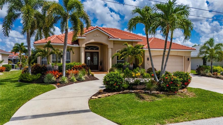 As the sun begins to set over the canal, this exceptional FERO built waterfront residence transforms into a private coastal retreat designed for elegant living and unforgettable entertaining. Nestled within the powerboat section of Punta Gorda Isles, the home captures the beauty of Southwest Florida living with breathtaking water views, seamless indoor outdoor flow, and luxurious designer finishes throughout. Soaring stepped ceilings, crown molding, tile flooring, and expansive zero edge pocket sliders create an atmosphere that feels both grand and inviting, while natural light pours into every thoughtfully designed space. At the center of the home, the gourmet kitchen serves as both a showpiece and gathering place, anchored by a dramatic 5x9 single slab quartz island and surrounded by upgraded custom cabinetry and a suite of top tier appliances including an Italian oven, smart refrigerator, drawer microwave, wine cooler, and farmhouse sinks in both the kitchen and laundry room. A panoramic bay window frames tranquil canal views, bringing the outdoors into everyday living and dining spaces designed for effortless entertaining and relaxed waterfront living. Privately tucked away, the primary suite offers a serene escape with direct access to the lanai, expansive walk in closet with custom built ins, and a spa inspired ensuite featuring dual vanities, a jacuzzi soaking tub, and an oversized walk in shower with pocket sliders to the laundry room from the closet. Two guest bedrooms provide inviting accommodations for family and visitors, each thoughtfully designed to reflect the home’s refined yet comfortable atmosphere. Outside, the expansive lanai becomes the true heart of the home as glowing sunset skies reflect across the water and create an unforgettable backdrop for evenings spent poolside. The outdoor living area features a sparkling pool, an outdoor kitchen with upgraded grill and refrigerator, and panoramic unobstructed canal views that elevate every moment. Boating enthusiasts will appreciate the 30 foot concrete dock and 10,000 pound boat lift with new motors and cables, offering quick access to Charlotte Harbor and an easy ten minute cruise to Fisherman’s Village. Complete with updated lighting, a 2023 roof, and pristine move in ready condition, this extraordinary residence embodies sophisticated waterfront living at its finest.