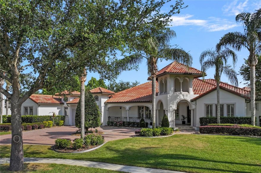 Back on the market through no fault of the home - Buyer's financing issue creates a rare second chance for this one-of-a- kind Windermere estate. Welcome to 5909 Oxford Moor Blvd—a beautifully designed, single-story Spanish-style estate on a .56-acre lot with mature landscaping, circular driveway, and tile roof. The courtyard layout includes a two-car and one-car garage. Inside, enjoy 4 bedrooms, 4 full baths, 2 half baths, and an office with hidden access to the luxurious primary suite featuring dual walk-in closets, dual water closets, a linen closet, wet bar with fridge, seating area, and spa-style bath with walk-in shower and soaking tub.  The chef’s kitchen boasts Bosch refrigerator and dishwasher, Dacor cooktop, microwave, double ovens, warming drawer, Thermador coffee machine, pot filler, two sinks, two disposals, and a hidden walk-in pantry. A wine pantry offers fridge, ice maker, storage, and wine rack. The home features cathedral ceilings, engineered hardwood, porcelain tile, Denon-controlled surround sound, Hunter Douglas motorized shades, plantation shutters, crown molding, cove and coffered ceilings, and built-ins throughout. A fully furnished media room includes a projector, wet bar, fridge, microwave, and half bath, with sliding glass doors to the screened pool and spa. The backyard offers a full summer kitchen, outdoor gas fireplace, and elegant entertaining space. French doors lead from the living areas to the screened lanai, enhancing indoor-outdoor living. Ideally located near top-rated schools, major theme parks, shopping, and dining, this one-of-a-kind estate combines quality, comfort, and convenience—all on one level. A truly timeless forever home with unmatched craftsmanship.
