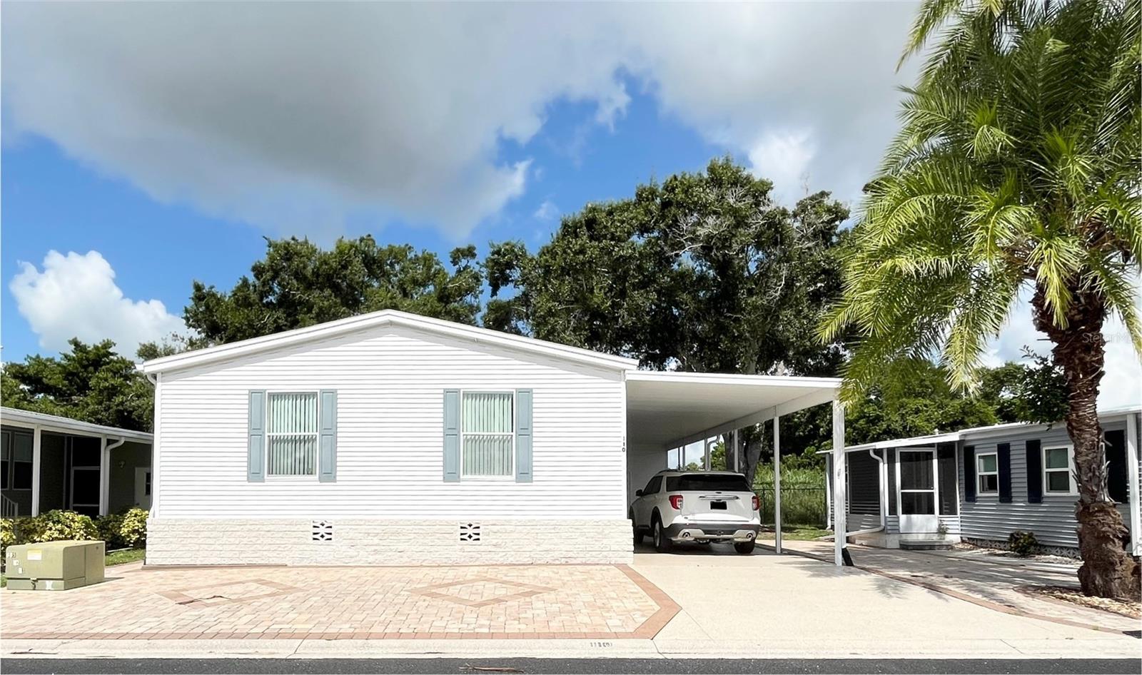 Welcome to your private oasis in the ONLY Resident Owned Park in the City limits of Sarasota!! Additionally this home is positioned on the West perimeter fence and is close to the resident only gate.
This lovely 1,620sf turnkey furnished 2 Bedroom/ 2 Bath with a large den(3rd bedroom) is a SPLIT PLAN Palm Harbor home and has many upgrades and luxury furnishings.
The home has exquisite curb appeal with decorative pavers, a stone paver knee wall around the perimeter, epoxy driveway and stone steps leading into all 3 entry doors. Upon entering the first upgrade you will notice is the entire home has drywall and crown molding throughout. The formal dining area features a beautiful oval table and server. The spacious living room has a high tray ceiling and large accent windows allowing for natural light. To your right enter into the large kitchen featuring ample cooking space with the sprawling stone bordered counters and backsplash. High cabinets and a step in pantry will meet all your storage needs. Just off the kitchen is a private breakfast/dinette space with a round table with seating for 4 and a decorative bench, a nook area for your laptop and documents and the washer/dryer area. The primary suite features a luxury king bed set and an en suite bath with a step in shower and additional walk in closet. Across the other side of the home is the beautifully furnished guest bedroom, a full sized den that could be used as a 3rd bedroom and the guest bath with a tub/shower. There is access to the storage shed inside the home just off the dinette space and thru the carport.
Other upgrades include: Shingle Roof 11/2024 and HVAC in 2020. The bedrooms and living area have all been outfitted with nice ceiling fans/lights.
Note: Insurance carriers were offering a 10% discount on Palm Harbor built homes - so be sure to ask when getting quotes for insurance.
The gated 90 acre community boasts a low maintenance fee with its vast amenities starting with the spacious Clubhouse outfitted with a full commercial cook kitchen, event stage, audio/visual, dance floor, state of the art fitness room, activities hall, library with books/movies/puzzles and a pool table. Outside recreation includes an extra large heated pool with a handicap ramp, a spacious kidney shaped hot tub, ample umbrella tables and lounge chairs and updated shower rooms. Oak trees shade the beautiful park area, picnic tables and a community grill. Additional amenities to enjoy are the community putt putt course, bocce ball, ping pong, horseshoes and corn hole. Oakwood Manor is a vibrant community with numerous social events and activities. Conveniently located adjacent to Legacy Trail and 12 newer pickle ball courts. Just a short drive to our crystal sand beaches, downtown area, the marina, fishing pier, local golf courses, shopping, variety of restaurants, the museum, SRQ airport, SMH and Doctors hospitals. Please note that Oakwood is a 55+, no pet, no motorcycle Park.