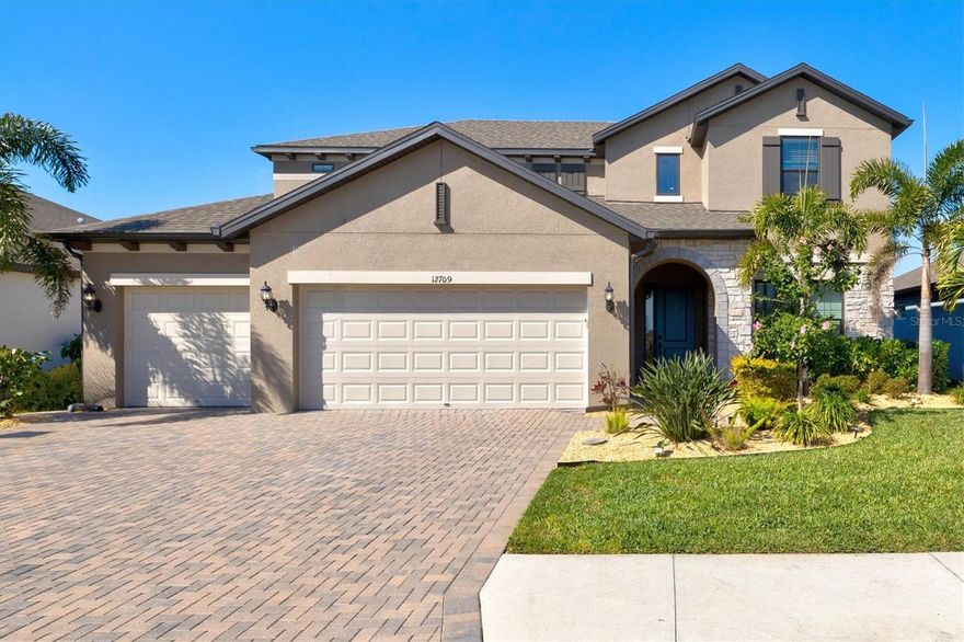 Built by MI Homes, this executive-style Juniper model in gated Promenade Estates offers modern luxury, privacy, and nearly 3,900 square feet of living space. Completed in 2022, the home welcomes you with a bright foyer and a flexible fifth bedroom/office behind French doors. The chef’s kitchen features a massive waterfall-edge quartz island, GE stainless steel appliances including double ovens, soft-close cabinetry, a farmhouse sink, vent hood, beverage fridge, walk-in pantry, and a custom shiplap coffee station. It opens to a spacious living room upgraded with custom coffered ceilings, hurricane IMPACT windows and doors throughout, as well as wiring for speakers. 

The first-floor owner’s suite feels tucked away and private, offering tray ceilings, dual quartz vanities, a seamless glass shower with rainhead, soaking tub, and a custom-built closet system. Upstairs, a large loft provides a second living space with built-in desks, plus three additional bedrooms—one with an ensuite—and an additional full bathroom with double vanity.

Pocket sliders open to a private preserve view with no rear neighbors, creating a seamless indoor/outdoor experience. The screened lanai is pre-plumbed for an outdoor kitchen and overlooks a heated pool and spa with lush tropical landscaping and an outdoor shower. Two AC units provide efficient climate control throughout the home, and the garage features additional shelving and durable epoxy flooring for added convenience.
Promenade Estates amenities include a community pool, splash pad, clubhouse, fitness center, playground, dog park, and sports courts. Located in Sarasota’s desirable Palmer Ranch, minutes from Siesta Beach, the Legacy Trail, top-rated schools, shopping, dining, and I-75.