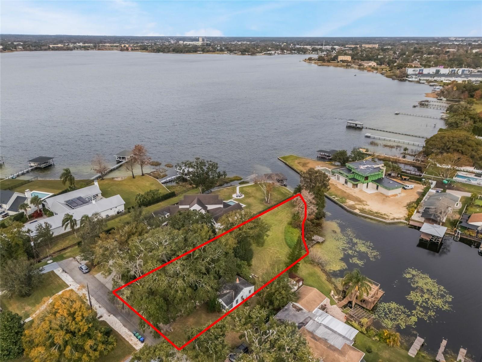 Discover a rare and extraordinary opportunity to create your dream home in the heart of Orlando’s coveted College Park neighborhood. This expansive .76-acre double lot boasts an impressive 125 feet of width and approximately 200 feet of serene shoreline on the beautiful Lake Fairview. With roughly half an acre of buildable space, this property offers the ideal canvas for designing the lakefront oasis you’ve always envisioned. Nestled on a secluded, low-traffic cul-de-sac street lined with mature trees, this property provides the tranquility you desire with NO HOA while being conveniently close to all that College Park has to offer. Enjoy the vibrant energy of Edgewater Drive with its charming shops and unique restaurants, explore the College Park Packing District, or spend an afternoon at the historic Dubsdread Golf Course. This property is being sold for the land value only. The existing structure is not available for showings and will need to be demolished by the buyer. Any new construction plans, including zoning, permits, impact fees, or potential lot splits, must be verified by the buyer with the City of Orlando. Seize this opportunity to craft a custom lakefront masterpiece in one of Orlando’s most sought-after neighborhoods. Properties like this are rarely found, so schedule your appointment today and start building your dream tomorrow! *Aerial photo property lines are an estimate and to be verified by buyer.