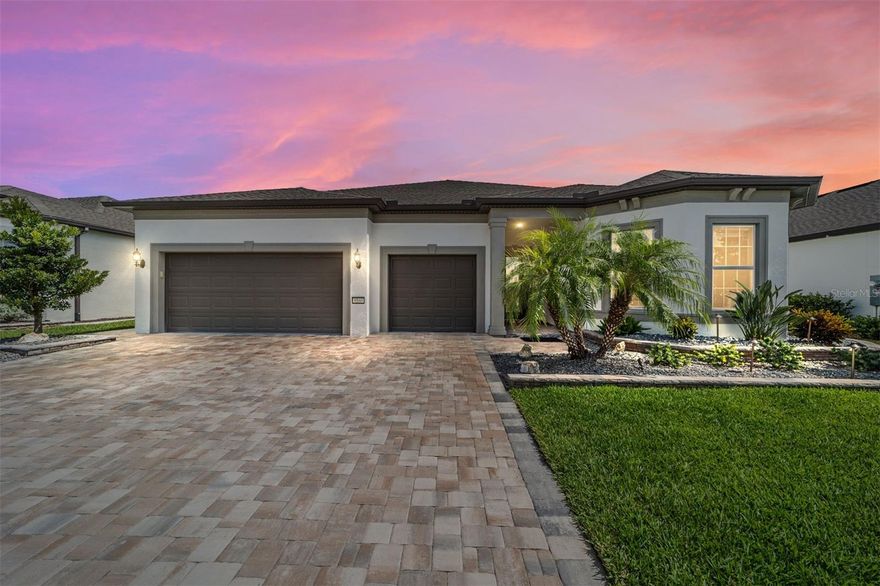 Welcome to a meticulously crafted Renown model home, offering a balance of luxury, comfort and efficiency in the sought-after, 55-plus community of Del Webb Stone Creek. This three-bedroom, 3.5-bath residence, spanning 2,808 square feet, is a showcase of modern living and thoughtful design. From the moment you enter, a striking paver driveway sets the tone for the elegance that awaits. Go inside and discover a home designed for effortless living. The open-concept layout features a grand gathering room with a tray ceiling and crown molding. Offset floor tile flows seamlessly through the main living areas and baths. The enclosed flex/den space offers the versatility to be a home office or a cozy reading nook. Sophisticated touches throughout the home include rounded drywall corners and custom window treatments. The heart of the home features a built-in KitchenAid cooktop/oven and convection microwave, touchless kitchen faucet, and a counter-depth LG ThinQ French Door refrigerator creating a space that is beautiful and highly functional. The luxurious owner's bath is a retreat, boasting a spacious Roman walk-in shower with dual handheld showerheads and stunning granite countertops. Outdoor living is enhanced by an extended screened-in lanai, offering a serene space to sip your morning coffee or enjoy the sunrise and nature. The home's design allows for a unique pass-through laundry room from the garage to the auxiliary closet and primary bath, offering an incredibly practical feature for an active lifestyle. Del Webb Stone Creek is more than a community, it’s an experience. Enjoy a wide array of amenities, including a championship golf course, a multipurpose path for walking and biking, and a relaxing and inviting atmosphere. Whether you’re booking your calendar full of activities or snuggling in with a good book, this home and community have everything you're looking for.