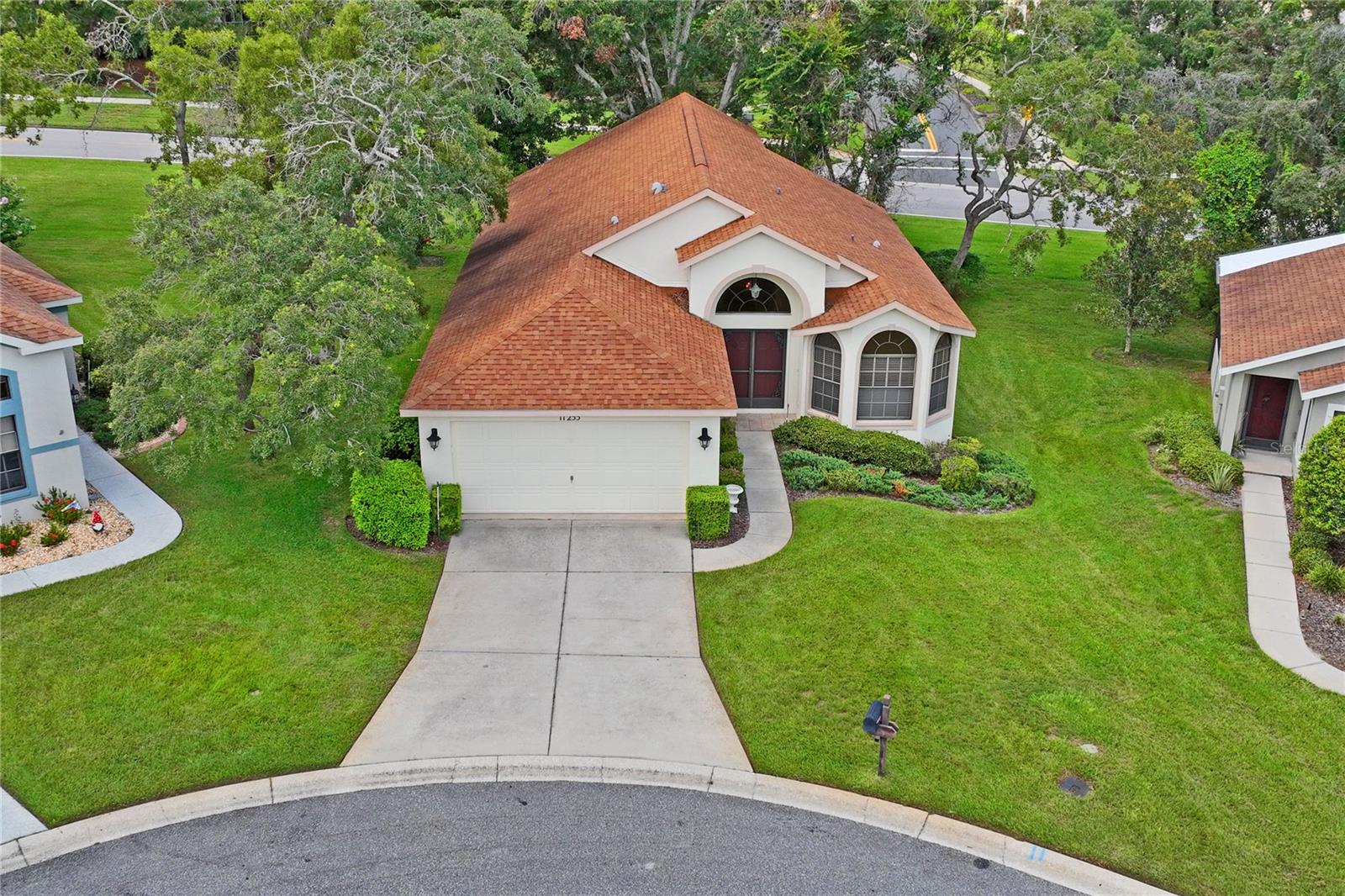 Beautiful and well-maintained home situated in a cul-de-sac location within the desirable 55+ community of Wellington at Seven Hills in Spring Hill. This popular Nightingale model by Ryland homes features a versatile floor plan including a large eat-in kitchen, separate dining room, indoor laundry room, and three bedrooms, of which one is located right off the living area and offers flexible functionality as den, study, or family room. Cathedral ceilings, architectural details, and transom windows contribute to the spaciousness of this home. The kitchen has all newer appliances, a large breakfast area plus a breakfast bar overlooking the living area Main bedroom suite includes two closets, one is a large walk-in closet, double vanities in the bath, and a convenient walk-in shower. Both additional bedrooms have good-size closets. You will find beautiful hard wood oak flooring in the living areas and third bedroom/den, ceramic tile in kitchen and baths, and carpet in the main and second bedrooms. Off the kitchen, there is an indoor laundry room with a laundry sink and additional cabinetry. Triple glass sliders lead to the screened and covered lanai offering a comfortable outdoor spot where you can relax and enjoy the view of the landscaped backyard from an elevated vantage point. This is a one-owner home, roof was replaced in 2017 and HVAC in 2014. The Wellington at Seven Hills is a gated 55+ community, centrally located with easy access to shopping, dining, medical services and hospitals, and major roadways including Suncoast Parkway for easy commute to Tampa and international airport. Community amenities include a beautiful club house with restaurant, Olympic-size pool, fitness room, meeting and computer rooms, tennis and pickle ball, and more. Nearby, enjoy the local attractions including Weeki Wachee State Park with its world famous Mermaids, Pine Island beach area, fishing piers, numerous boat ramps and kayak launch areas or take a short drive to Homosassa Springs State Park or visit Brooksville for many other activities and festivals throughout the year.