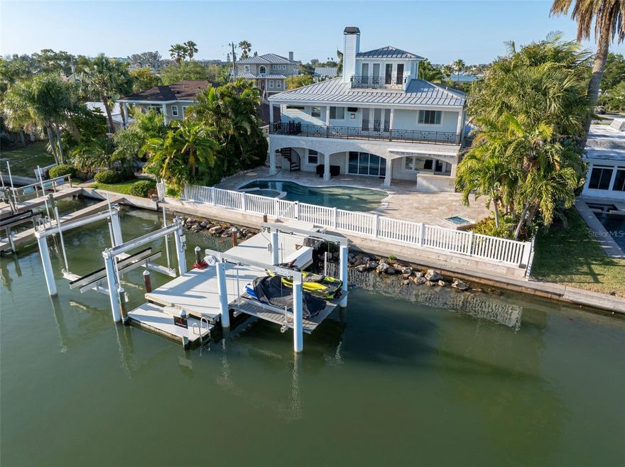 Welcome to your waterfront Seaside Sanctuary nestled along the intracoastal waters of historical IRB Florida.  This magnificent residence offers the epitome of luxury beach living. Boasting unparalleled waterfront views and exquisite amenities throughout. There is nothing left to do in this home that was built for maximum comfort and ultimate relaxation.
The home boasts 5 bedrooms and 5 full baths and is 3,846 sq feet.  The exquisite amenities include a stunning salt -water pool and spill-over spa perfect for entertaining guests. The backyard space covered in beautiful travertine also boasts a covered outdoor kitchen with a 42- inch natural gas grill, a built -in fire pit and outdoor entertainment center with a high end 75 inch full sunTV.  Imagine sitting in your pool and watching your favorite show from your pool float, drink in hand! Just past the walk -in pool and through the seawall fence you will find a large composite deck with plenty of room for your beach equipment, a platform that can hold 2 jet-skis and a separate 20,000 lb boat lift. 
The home showcases impeccable craftsmanship and attention to detail. As soon as you walk into the custom-made double front doors and into the expansive foyer you can see that no expense has been spared. This beautiful entryway has views of the intracoastal water way and leads into the modern chef’s kitchen, with granite countertops, a gas range, double refrigerator and brand-new ice machine and wine cooler. The open concept kitchen and dining area also has a fireplace for those nights you want to watch the sun go down while making dinner for the family.  There are 3 large bedrooms on the main floor, one of which was used as a home gym where a jacuzzi tub was installed for the ultimate cool down after a hard work out. The floor to ceiling sliders seamlessly blends the indoor and outdoor living spaces and can be left open to enjoy the salty sea breeze from the Gulf of Mexico.
Convenient amenities include: a pool shower and bathroom just steps from your outdoor private oasis.  The state-of-the-art laundry room connected to the pool bath and 2-car garage ensures that the rest of your home remains sand and water free while going back and forth from the beach to the pool. Speaking of, the beach is only a short walk, bike, or golf cart ride away.  You truly have the best of both worlds! 
Ascend to the Master bedroom where panoramic vistas await. Step through the elegant French doors onto your balcony commanding views of the pool and sparkling waterway. A convenient spiral staircase grants easy access to the pool day or night. Within the en-suite a dual fireplace connects the large jacuzzi tub to the master suite, complemented by his and her vanities and a generous shower with dual heads and a linen closet. Adjacent to the fireplace lies a cozy lounge area and an in-room bar for your coffee or cocktails alongside a very large walk in closet. Additionally, a guest bedroom and bath are on this level ensuring comfort and convenience for visitors. 
Perhaps one of the most stunning features of this home is the 3rdfloor. This literally elevated home office, gym or even an art studio is surrounded by windows and French doors that open to yet another private balcony and the most spectacular views of the island- Everything in this house has been meticulously thought out so all you have to do is move in!