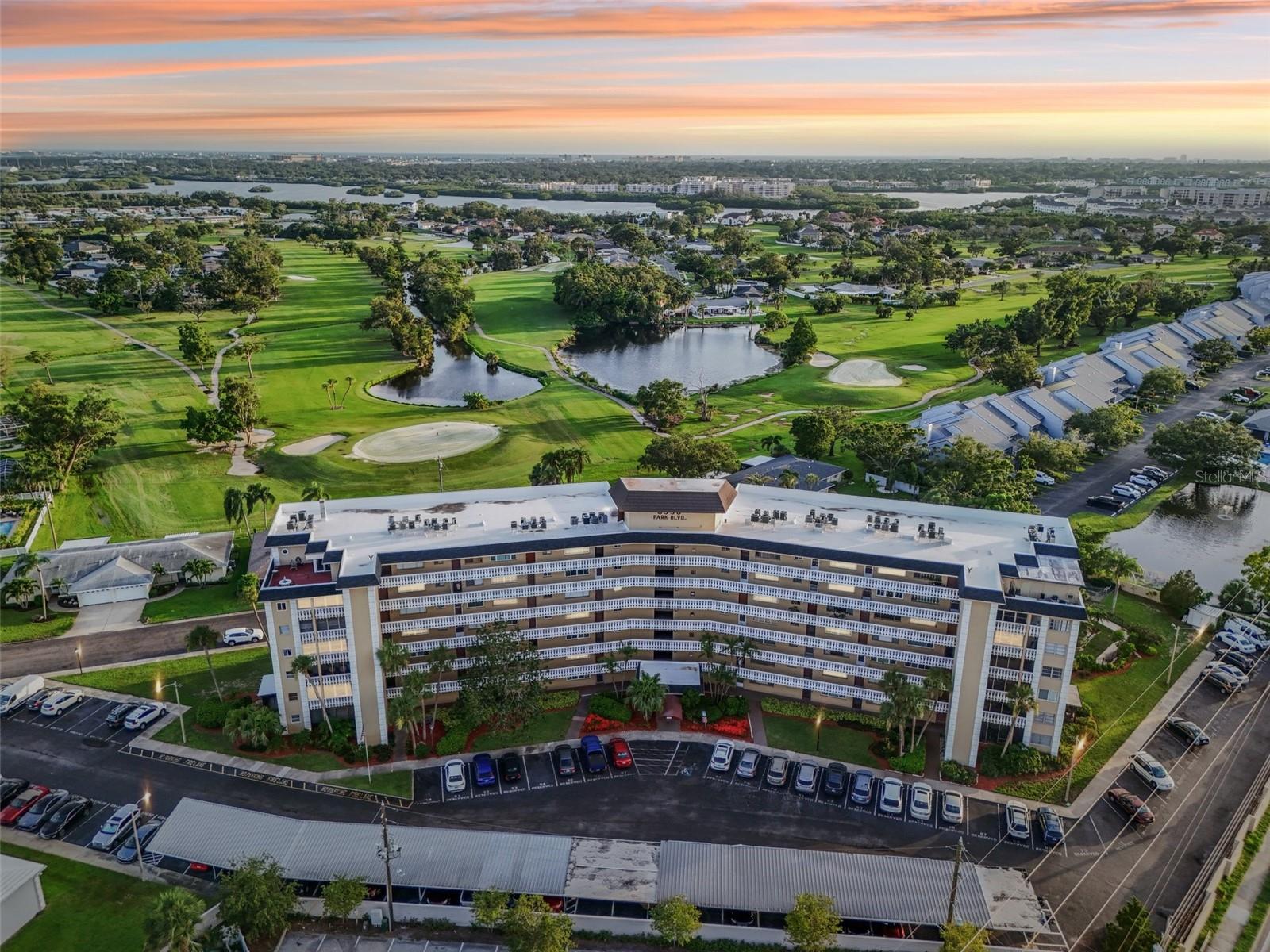 Stunning golf course and pond views from a light-filled corner unit! Welcome to the Cavalier Building, located in the Lake Seminole Country Club neighborhood. This beautifully positioned mid-rise condo offers unbeatable views and abundant natural light from its many windows—thanks to its inner corner-unit location. From sunrise to sunset, you’ll enjoy watching the sunlight move across the golf course and surrounding ponds. These peaceful, panoramic views will never get old. The unit's layout is just as ideal: a split-bedroom floor plan offers privacy, with the primary suite showcasing direct views of the greens, and the second bedroom perfect for guests or use as a home office. Both bedrooms feature walk-in closets with built-in shelving. The primary bath has an easy step-in shower, while the guest bath provides a full tub for those who enjoy a relaxing soak. Throughout the home, matching vinyl flooring accentuates the open layout and adds a cohesive, modern touch. The combined living and dining areas are comfortable and bright, with remote-controlled ceiling fans that include dimmable lighting. The kitchen may look compact, but it has ample storage with two deep closet pantries, white wood cabinets, stainless steel appliances, a dual sink with sprayer faucet, six electrical outlets, and a newer garbage disposal. Additional upgrades include:
• Nest thermostat (app-controllable while you're away)
• Roll-down screen door
• Impact-rated windows throughout
• 2025 NEW ELECTRICAL PANEL!
This reinforced concrete building has stood strong through multiple hurricanes, with owners consistently feeling safe and secure. The condo is equipped with PGT storm impact windows, and no flooding occurred during the most recent fall storms. Enjoy the convenience of two well-located parking spaces—#62 in the front row (uncovered) and #22 under a covered carport. The secure building features a gated lobby entrance, elevator, and a central mailroom under the front awning for protected package deliveries. Each floor has its own laundry room, and a private locked storage closet (#5) just steps from the condo. The trash chute, elevator, and laundry are close—but not so close that they cause disturbance. Monthly Dues: $618.26 — covering:
• Cable and internet
• Water, Trash
• Roof, Exterior maintenance & Building insurance
• Private roads, Carports
• Professional property management.
Community Amenities:
• Heated swimming pool
• Gazebo grilling area (a rare perk!)
• Car wash station
• Clubhouse with full kitchen, dining space, pool table, piano, and library.
Located at the corner of Park Blvd and Park St, this home is close to it all—groceries, restaurants, gas stations, and a pharmacy are all within a mile. Enjoy the outdoors at Seminole Lake Park, the kayak launch, or the gulf beaches—just 15 minutes away. Easy commutes to downtown St. Pete (15 min) or Tampa (30 min) round out this perfectly placed property. Don’t miss the opportunity to live with beauty, convenience, and amenities every day!