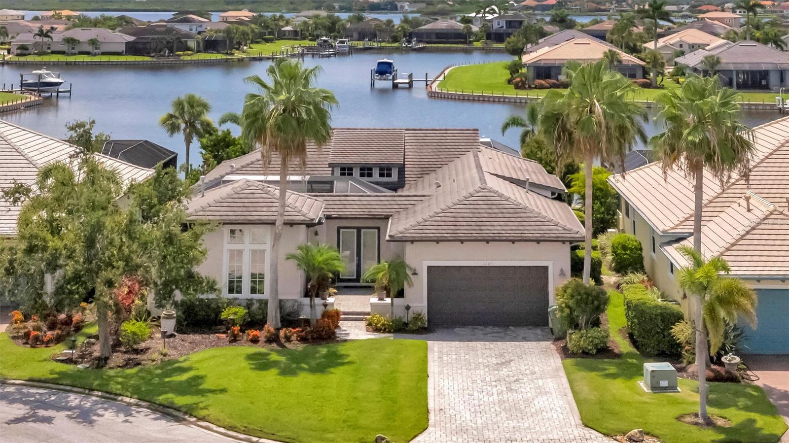 Boater’s Paradise in Tidewater Preserve! Welcome to this stunning former WCI model home—a fully furnished, turnkey 3-bedroom + den, 2.5-bath, 2-car garage retreat with a private pool, spa, and your own dock and boat lift offering direct access to the Manatee River. This exceptional home is a dream come true for boating enthusiasts, seamlessly combining luxurious interior features with the ultimate waterfront lifestyle. From the moment you step into the foyer, you’ll be captivated by the unique layout and exceptional attention to detail. At the heart of the home is a beautifully designed private courtyard, complete with lush greenery, pavers, and a charming seating area—perfect for both entertaining and quiet relaxation. The courtyard connects all sides of the home, creating a seamless indoor-outdoor flow within one of WCI’s most sought-after floor plans. The elegant dining area flows into a chef’s kitchen that exudes both warmth and sophistication. Cream-glazed cabinetry, granite countertops, a tile backsplash, and under-cabinet lighting set the stage, while KitchenAid natural gas appliances, pot filler, butler’s pantry, wine bar, and generous storage make it a cook’s dream. The oversized island even features under-counter refrigerator and freezer drawers for added convenience. Just off the kitchen, a flexible bonus room can serve as an office, breakfast nook, or additional guest space. The spacious living room, featuring custom cherry built-ins, opens to both the central courtyard and the resort-style pool and patio. Expansive hurricane-impact windows and sliding glass doors flood the home with natural light throughout. Throughout the home you will find real hardwood and tile flooring, porcelain and travertine bathrooms, plantation shutters, crown molding with rope lighting, high ceilings, and a built-in central vacuum system for added convenience and cleanliness. Step outside to your own backyard oasis featuring a sparkling pool with two water fountains and fire bowls, a relaxing spa, and the crown jewel—your private dock and boat lift just steps away from the lanai. Located in the gated, waterfront community of Tidewater Preserve, you'll enjoy access to top-tier amenities including two clubhouses, three pools, fitness center, tennis courts, kayak launch, walking trails, and more. This is more than a home—it’s a lifestyle.