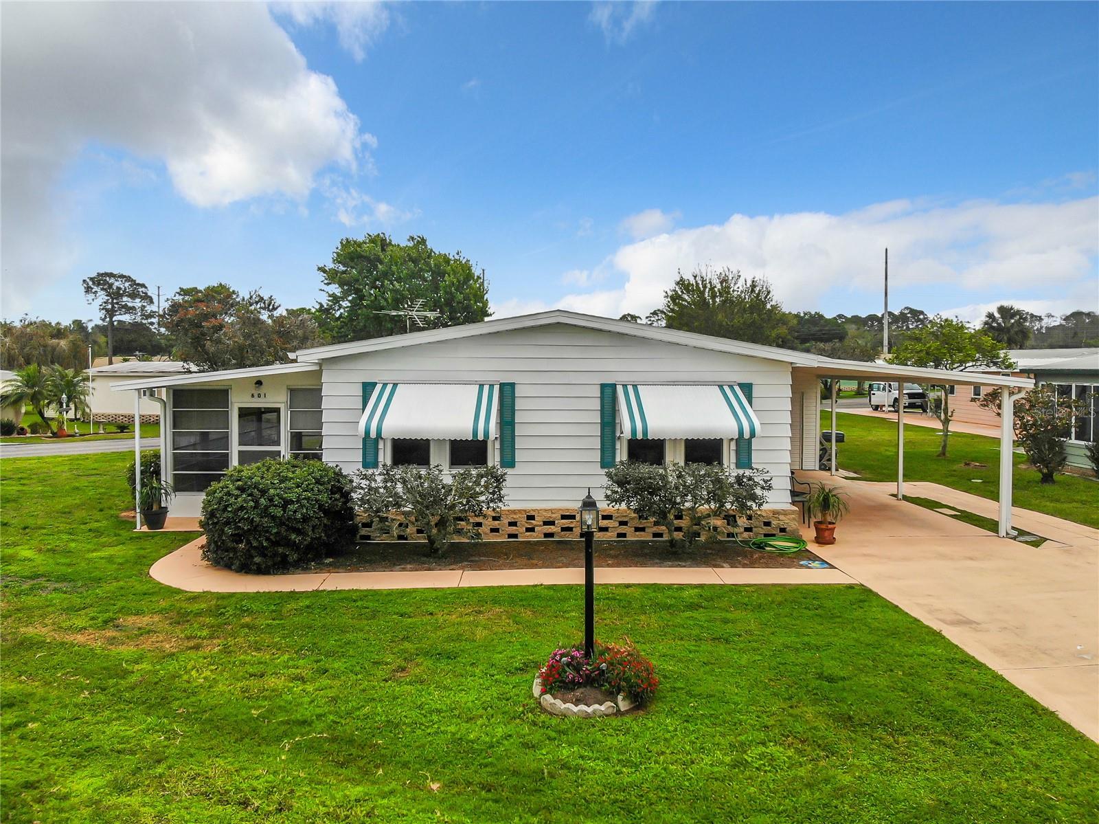 GREAT HOME! Welcome to KOVE ESTATES, a community that offers resort-style living, comfort, and convenience. This 55+ Co-Op, Gated Golf Course community offers all the fun without all the fuss. This home features 2 bedrooms, 2 bathrooms, a spacious family room and kitchen with natural light, dining room with built in storage. The screened in Florida room ideal for relaxing and entertaining during the cool Florida evenings. The home also has an indoor laundry/Storage room, an oversized carport. Updates include Newer Laminate Flooring throughout, Updated Double Pane Windows, Smart Dehumidifier and New Thermostat, New Toilets, New Moen Kitchen faucet, Storm Shutters and an Oversized corner lot. In a NO Flood Zone. As a resident of The Kove Estate, you will enjoy free 9-hole golf, two pools (one heated), tennis courts, pickleball, community events, Clubhouse, Library, and gated security. The community is conveniently located off SR415, minutes to Sanford, Deltona, New Smyrna Beach, close to shopping, dining, medical facilities, and attractions such as the Daytona International Speedway, the Kennedy Space Center, and the Orlando theme parks. Perfect for anyone looking for a peaceful and convenient lifestyle. Call today to view! Come see this home today.
