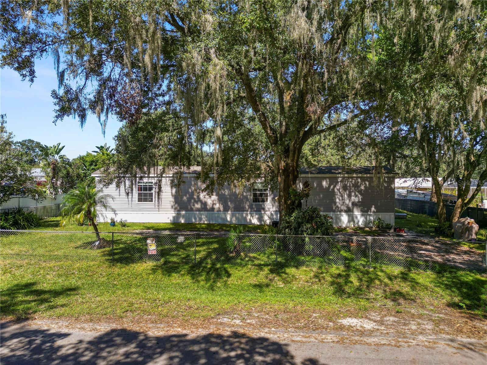 Take a look at this 2 bedroom 2 bathroom home located on a fenced in lot with NO HOA! This home features an open floor plan and split bedrooms. The living area features laminate flooring and plenty of natural light. The kitchen is spacious with plenty of cabinet and counter top space and a large pantry/laundry room. The primary bedroom offers plenty of space and features an en suite with a single sink vanity, tub/shower combo and walk in closet. You’ll find the second bedroom on the opposite side of the home with carpeted flooring and a walk in closet. The main hall bathroom features a single sink vanity and a tub/shower combo. The 3 TV's (2-55",1-65") will also remain with the home. Outside you’ll find a block outbuilding with the well pump. This home has so much to offer! Schedule your private showing today!