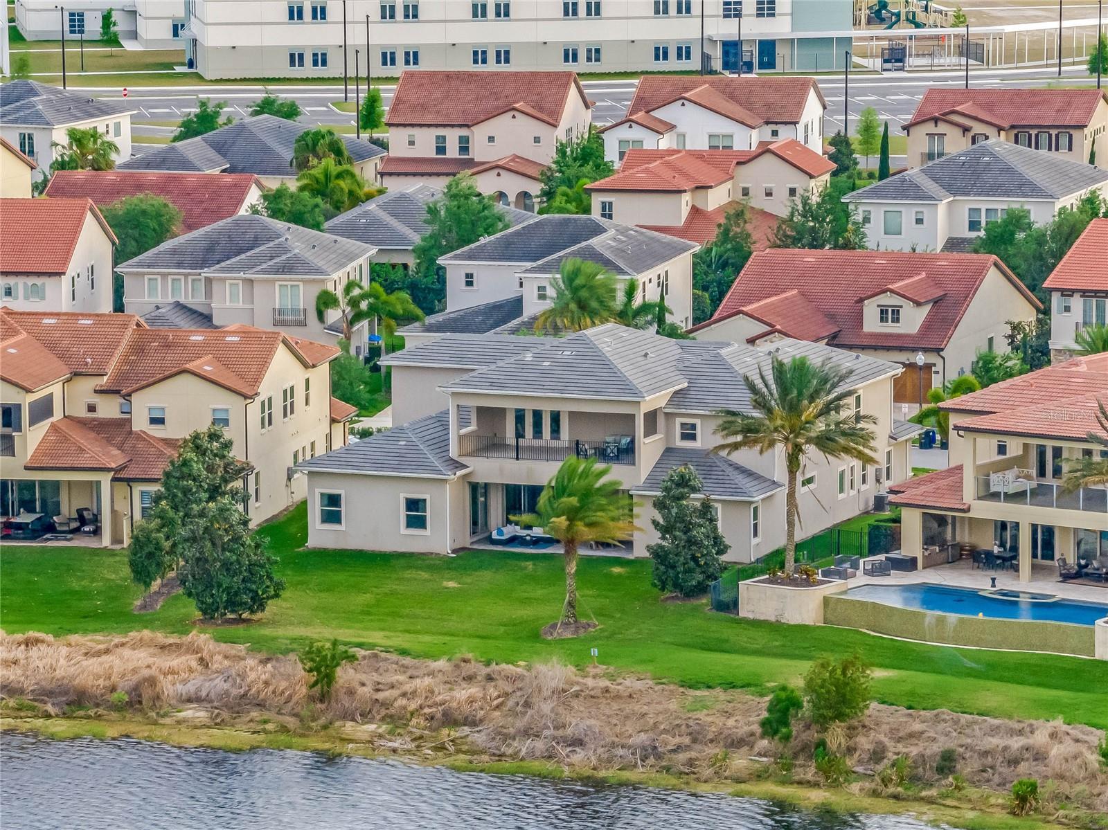 One or more photo(s) has been virtually staged. Welcome to Paradise! Have the best of both worlds, where you can staycation and create your own magic in the perfect home for entertaining and living it up! As one of the closest lakefront home communities in the world to Disney's Magic Kingdom (2.8 miles from Cinderella's Castle to be precise), Lakeshore Preserve offers many social lifestyle choices, including 4 monthly community gatherings, ladies bunco, family games, etc! Panther Lake Elementary, Water Spring Middle & Horizon High School are all around the corner. This "Palm Beach" Santa Bella model by Toll Brothers is a spacious, two-story, ~5,250 square foot Estate Home, with 6 bedrooms and 5.5 baths. Once inside, it begins in the two story atrium, where natural light beams through the tall windows all day long with its southerly exposure to the front, while you gaze out the back at the breathtaking views of Panther Lake though the formal dining room's quadruple sliding glass doors. Enhancing the paradise theme here are cool, exotic interior accent walls of turquoise and plum, while the custom whirly modern-glass chandeliers above are just fun! Porcelain wood plank tile floors carry you throughout the main level, leading you to the gourmet entertaining kitchen, featuring not one, but two custom quartz islands for plenty of capacity to entertain. It's fully equipped with plenty of additional counter space, custom cabinetry, KitchenAid appliances including dual multi-functional ovens, a gas range with hood, a stainless farmhouse sink, a built-in ice maker and a wine cooler. Beyond is the family room, offering more views of the lake, and its own triple sliding glass doors that lead you to the paver Lanai. You've got an almost .4 acre oversized lot to play with when you step out back! 66' of your very own lake frontage. Back inside, the primary suite features tray ceilings with molding, views of the lake with lots of light, and his & her's closets with a window. The primary bath features large symmetric quartz vanities with Kohler sinks and natural warm light coming in from the west. The primary bath's most prominent feature, besides its sheer size, is a full glass triple-sized shower, including custom tile work, a built-in quartz bench, and triple shower heads- like its own steam room! Also on the main level, through its private entrance, is the next-generation suite with its own living room, 2023 kitchenette, a bedroom with walk-in closet, and a full bathroom with tub. Heading upstairs, you'll be greeted with a loft/entertaining area with plumbing for a wet bar. This leads directly to the oversized upstairs terrace with 270 degree elevated views of Panther Lake- stunning, and so relaxing and private up here, especially during sunsets. Head back inside and into the movie theater/game room for the after party! On the opposite side of this second level are the remaining 4 bedrooms & 2.5 bathrooms. Other features: Endless gas water heater, Nest smart climate control and security system, rough-in's for; gas fire pit, wet bar, summer kitchen. With the house being less than five years old, you'll have peace of mind for many years to come. All exterior landscaping and pest control is covered by your HOA dues! Lakeshore Preserve's Amenity Center is just ~500 feet away, with a full gym, party room, resort-style pool, playground, beach volleyball, community dock with kayak & paddle boards you can grab at any time. View Disney's fireworks nightly from your front porch...Magical paradise anyone?