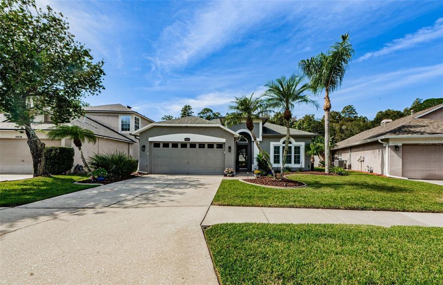Framed against a lush conservation, this gorgeous home boasts all the stunning features and finishes you’d expect in Westwood Lakes. This stately residence was even treated to an impressive list of high-end updates: NEW roof (2015), NEW impact windows (2018), NEW custom kitchen (2020), NEW custom master bath (2020), NEW A/C (2022), and NEW water heater (2023). Additional aesthetic improvements include a FRESH COAT of exterior paint and a NEW patio awning (2017), FRESH COAT of interior paint for the living, dining, and great rooms (2022), BRAND NEW color-matching gutters and patio paint (2023). This 4 bedroom/2 full bath/2 car garage pool home not only showcases the ideal split floor plan to separate the master suite from the secondary, but additional upgrades of note extend to lovely plantation shutters throughout and porcelain tile flooring in the main living area. While hardwoods grace the bedrooms, stylish pavers adorn the front entry and the back exterior patio. You can count a Culligan water softener and reverse osmosis filter as welcome enhancements. Between the crown molding and arched doorways, natural light floods the impeccable living and dining rooms. The gleaming eat-in kitchen exemplifies understated elegance with recessed lighting shining down on contemporary cabinets and countertops that contrast against a glass tile backsplash and stainless appliances, including a gas stove. An adjacent family room just made for entertaining or relaxing includes a set of sliders to the resort-style outdoor space. Fully fenced and surrounded by luxuriant greenery, you’ll relish the fire pit, covered dining area, and sun ledge. The freeform pool sparkles. As for the master retreat, it is wonderfully cozy and accompanied by a spectacular bath with a striking custom tile design. The 4th bedroom is equipped with a great built-in desk to either work from home or to plan the wonderful galas you’ll wish to host! The community itself is simply a brilliant breath of nature dotted with magnificent pine trees. From walking trails, wetlands, and freshwater lakes to a sports field, basketball court, and playground, you’ll find the lifestyle you’ve been longing for on Weeping Elm Drive.