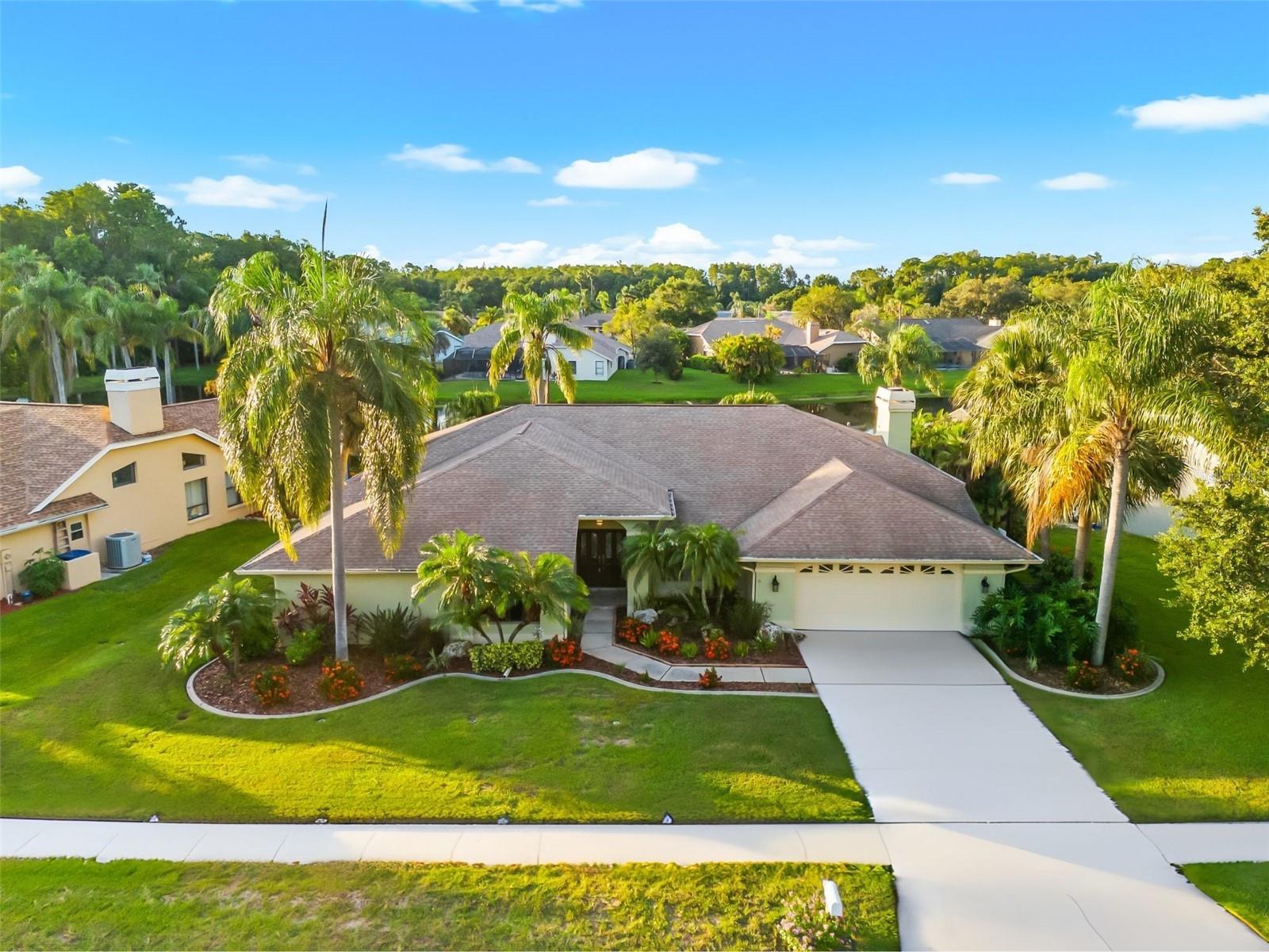 Welcome to this beautifully appointed 4-bedroom, 3-bathroom solar heated pool home nestled in the highly sought-after Lakeshore Village at Woodfield community in Tarpon Springs. Situated on a 0.27-acre lot with 74 feet of pond frontage, this custom-built Florida-style residence offers tranquil water views, privacy, and over 3,000 square feet of thoughtfully designed living space.
Step inside to find cathedral and vaulted ceilings, crown molding, and a bright, open layout perfect for both everyday living and entertaining. The split bedroom floor plan includes a spacious primary suite with a walk-in closet and an ensuite bathroom, all located on the main floor for easy access.
The kitchen features granite stone countertops, abundant white Shaker cabinetry, granite backsplash, both high and low bars perfect for countertop snacking! An eat-in dinette that overlooks the family room & pool patio creating the perfect gathering area. Recently installed panaramic screen enclosure! Additional interior features include ceramic tile and wood flooring, ceiling fans throughout, and a cozy wood-burning fireplace.
Enjoy year-round outdoor living in the screen-enclosed, solar-heated pool, set against a peaceful pond backdrop. The covered lanai and patio are ideal for relaxing or entertaining. The exterior is well-maintained with irrigation, rain gutters, sidewalks, and mature landscaping.
Located in a quiet, well-established neighborhood with sidewalk-lined streets, you’re just minutes from top-rated schools, parks, restaurants, and beautiful Gulf beaches. Zoned for East Lake schools and close to both Tarpon Springs and Palm Harbor amenities. A/C 2019, Roof 2010.
Don’t miss your opportunity to own a meticulously maintained pool home with water views in one of North Pinellas’ most desirable communities.