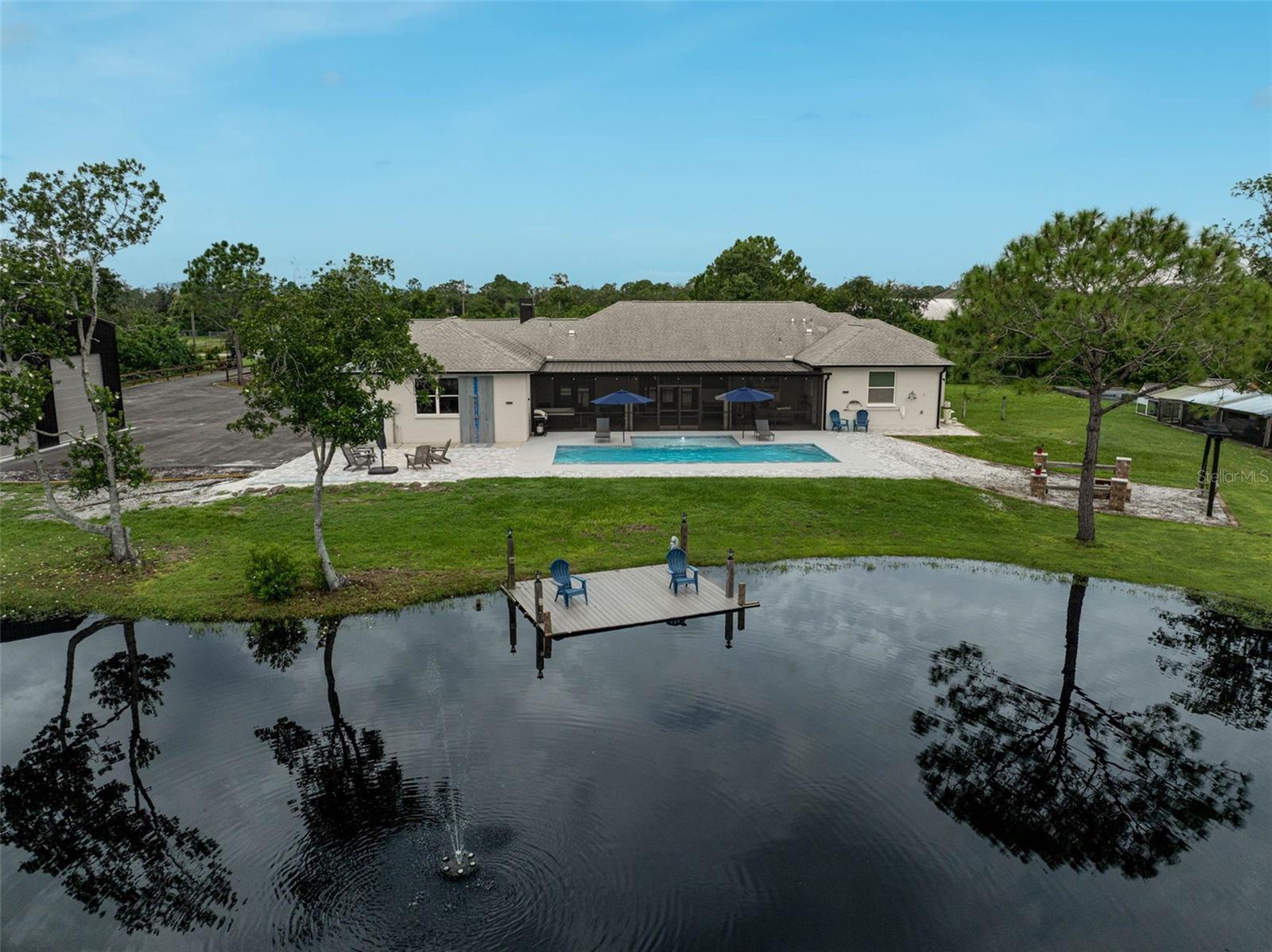 Discover the best of country living with this beautifully updated estate in the Magnolia Hill community of Myakka City. Nestled on 5 acres, this gated property offers both privacy and convenience, located just a short drive from Lakewood Ranch and Sarasota. The 3,100+ sq. ft. home has been extensively renovated since 2019, featuring 4 bedrooms with walk-in closets, an office, and a spacious bonus room, and an open-concept design ideal for everyday living and entertaining.
The chef’s kitchen showcases dual sinks, wall ovens, an island prep station, a walk-in pantry, and abundant storage. Recent upgrades include a dog wash station in the garage, making the home functional and thoughtfully designed. Outdoor living shines with a sparkling pool, fire pit, and a stocked pond with bass, tilapia, bluegill, and crappie.
Additional highlights include RV electric hookup, metal canopy storage bay for equipment, pole barn for the boat, metal building that could be finished for additional living or entertainment space and ample space to add stables. Magnolia Hill is an equestrian-friendly neighborhood with estate-sized parcels, allowing room for horses, cattle, and more. This property blends modern comfort with classic Florida charm—ready to enjoy today.