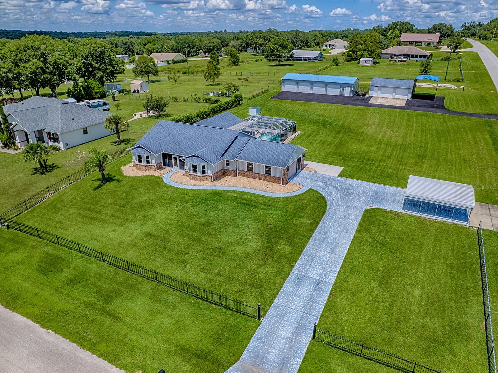 Priced to Sell Fast - Private Paradise with Large Pool, Over an Acre and Endless Storage!
This spacious 3-bedroom, 2-bath home near the Villages offers 2,403 sq ft of living space and sits on just over an acre corner lot with multiple entrances. Perfect for those seeking privacy, room to spread out, and plenty of space for entertaining, hobbies, vehicles, or home based businesses.
Step outside to your own backyard oasis featuring a inground pool with waterfall, large patio deck, and screen enclosure — perfect for year-round Florida living. Enjoy evenings by the large firepit or let your furry friends roam in the dedicated dog run, which even connects directly into the tiled recreation room. This versatile room, complete with a split A/C unit, is ideal for entertaining, relaxing, or as a custom space for dog lovers and breeders.
Car enthusiasts and hobbyists will love the multiple garage options featuring a attached 2-car garage with storage, 2-car carport, 24x30 2-car detached garage, 24x60 4-car detached garage and oversized carport perfect for a boat or RV along with a separate entrance and plenty of paved parking.
Inside, you’ll find a warm and inviting atmosphere, enhanced by custom ambiance lighting in both the kitchen and living room—perfect for setting the mood for a quiet evening or a lively gathering. The home also features a camera monitoring system, giving you peace of mind whether you’re home or away. In the living room, a unique lighted waterfall feature framed by glass block also provides natural light—originally a wood-burning fireplace that could easily be restored if desired.
Recent updates include: new roof (2018) and new A/C & windows (2022). For peace of mind, the seller is including a 13-month home warranty with the sale.
Whether you’re a car collector, hobbyist, pet lover, or simply looking for a home with lots of space, this home delivers!