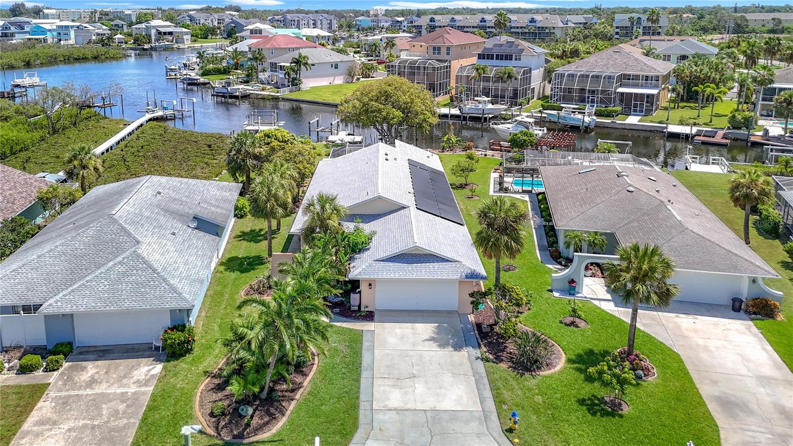Listed to sell below appraised value! Welcome to your tropical oasis in the highly sought-after Gulf Harbors Woodlands. This rare 3 bed, 3 bath, plus an office, offers 2,359 sq ft of living space on a private, oversized lot with lush landscaping, fruit trees, and serene estuary views. The home also comes equipped with paid-off solar panels, offering energy efficiency and significant cost savings for years to come.
Inside, enjoy an open Great Room layout with vaulted ceilings, hardwood floors, and two sets of French doors that lead to a massive 37’ x 24’ screened lanai, perfect for indoor-outdoor living. The updated kitchen features quartz counters and brand-new stainless appliances.
The spacious primary suite includes hardwood floors, crown molding, walk-in closet, and two full bathrooms. One includes spa-like features and lanai access. Secondary bedrooms are generously sized, with hardwood or carpeted floors, ideal for guests or a home office. The third bathroom is a showstopper, featuring travertine finishes and a custom rain shower.
Boaters will love the 84’ seawall, private dock with lift, and direct Gulf access. With low-maintenance living enhanced by the home's fully owned solar energy system, you can enjoy comfort without sacrifice. Community amenities include a pool, tennis courts, clubhouse, and boat ramp. Move-in ready and made for relaxing, just unpack and enjoy.